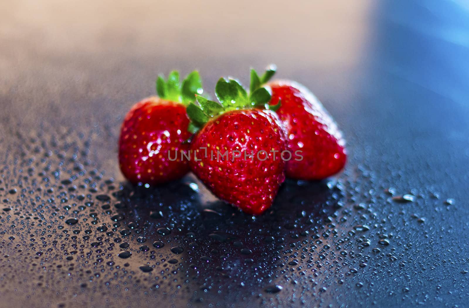 red, fresh strawberries in drops of water