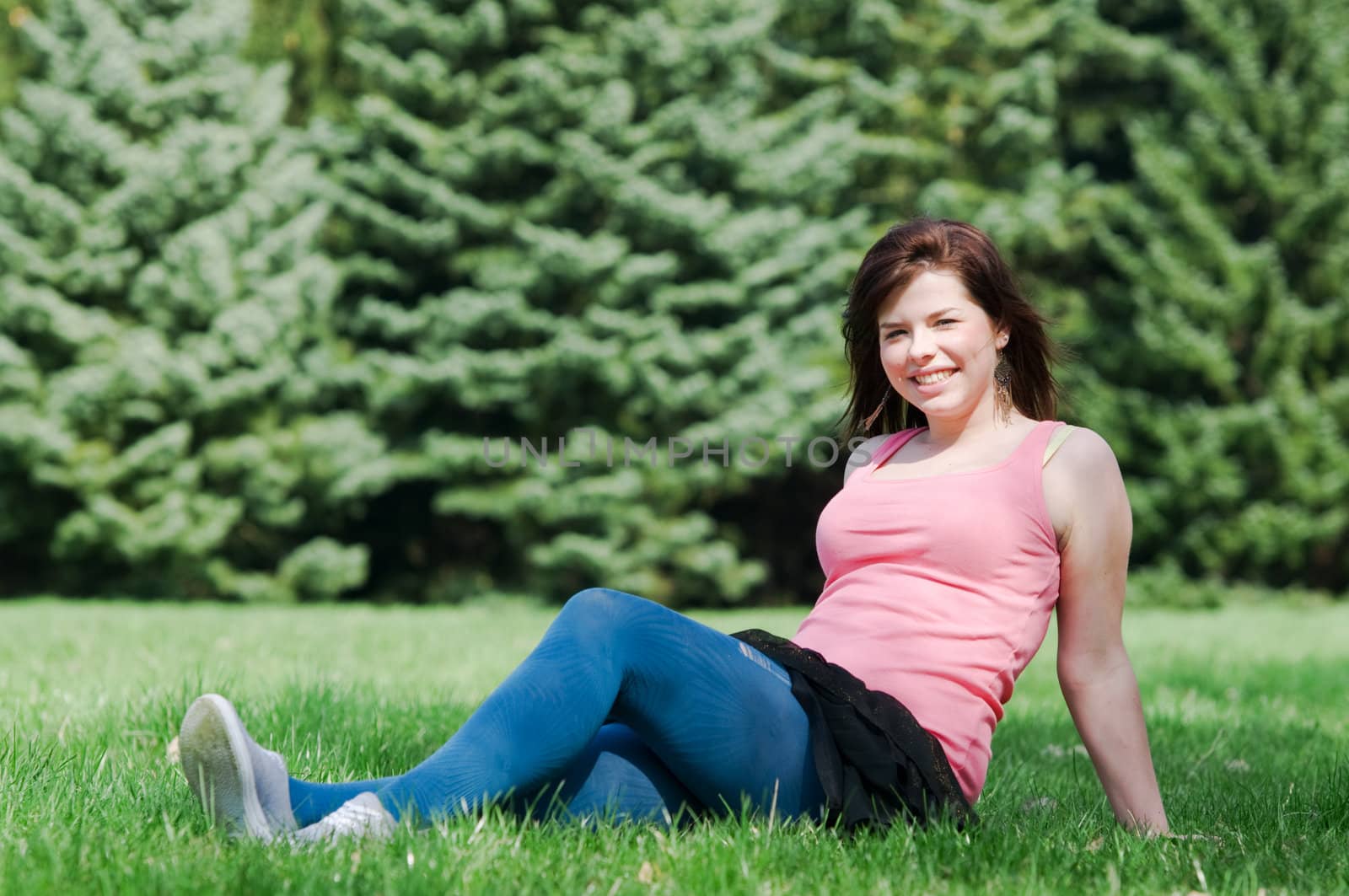 Young happy smiling girl lying on grass