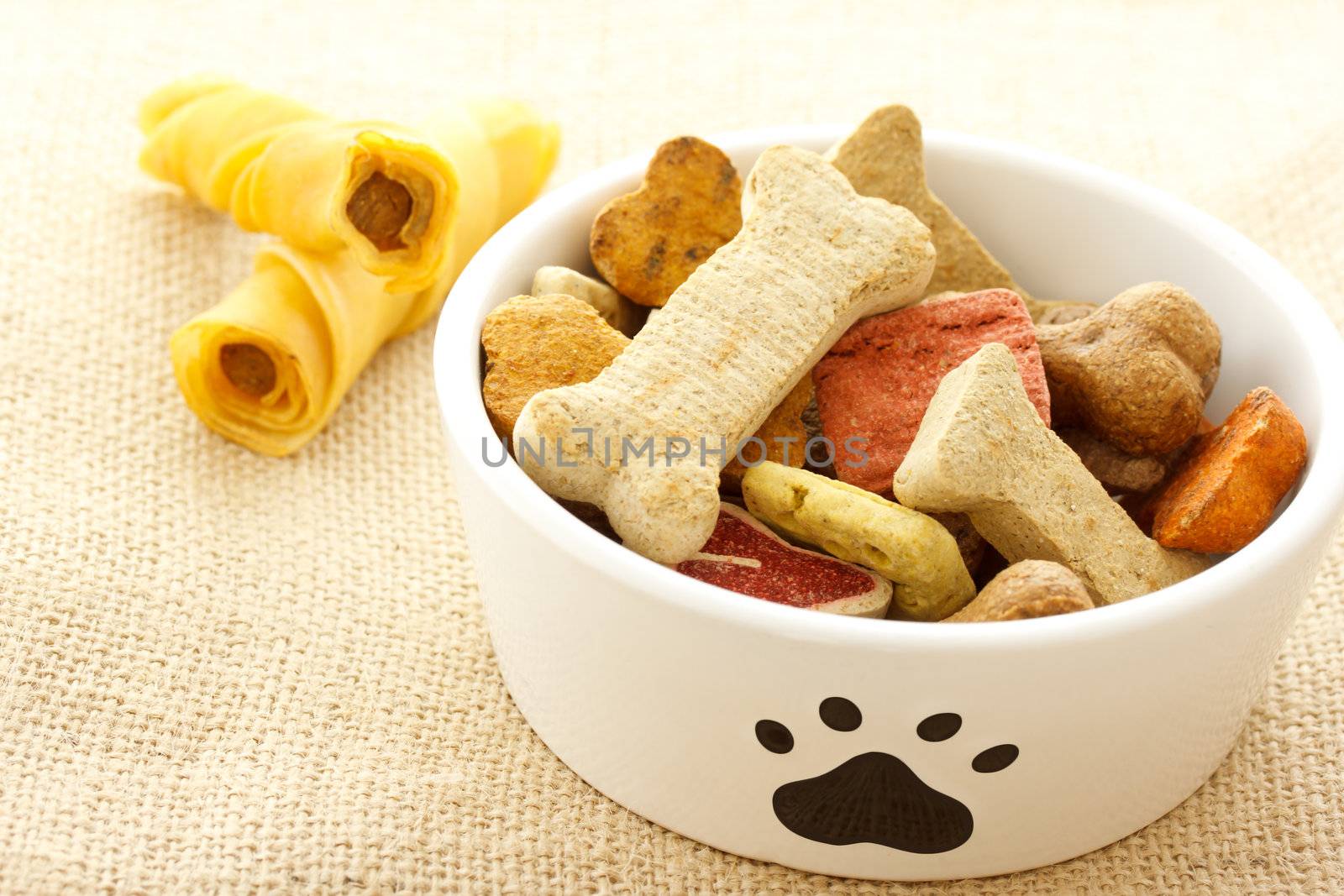 Dog treats in white bowl on burlap cloth