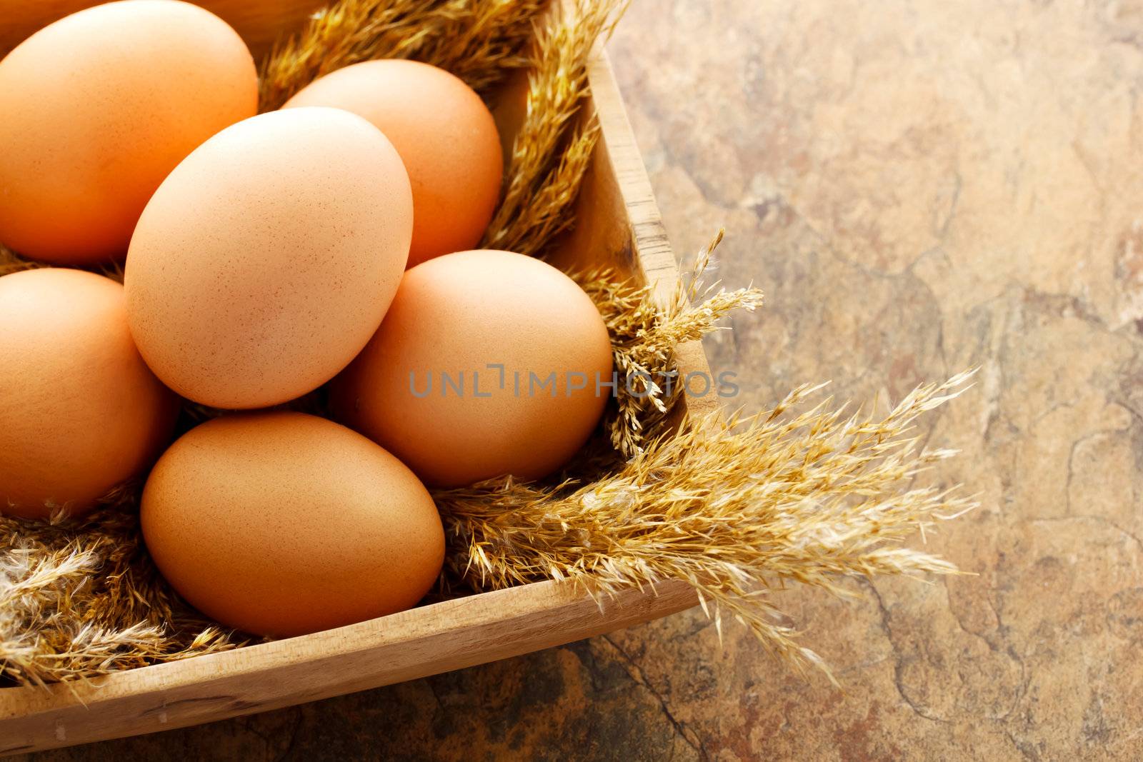 Brown eggs in wooden square bowl