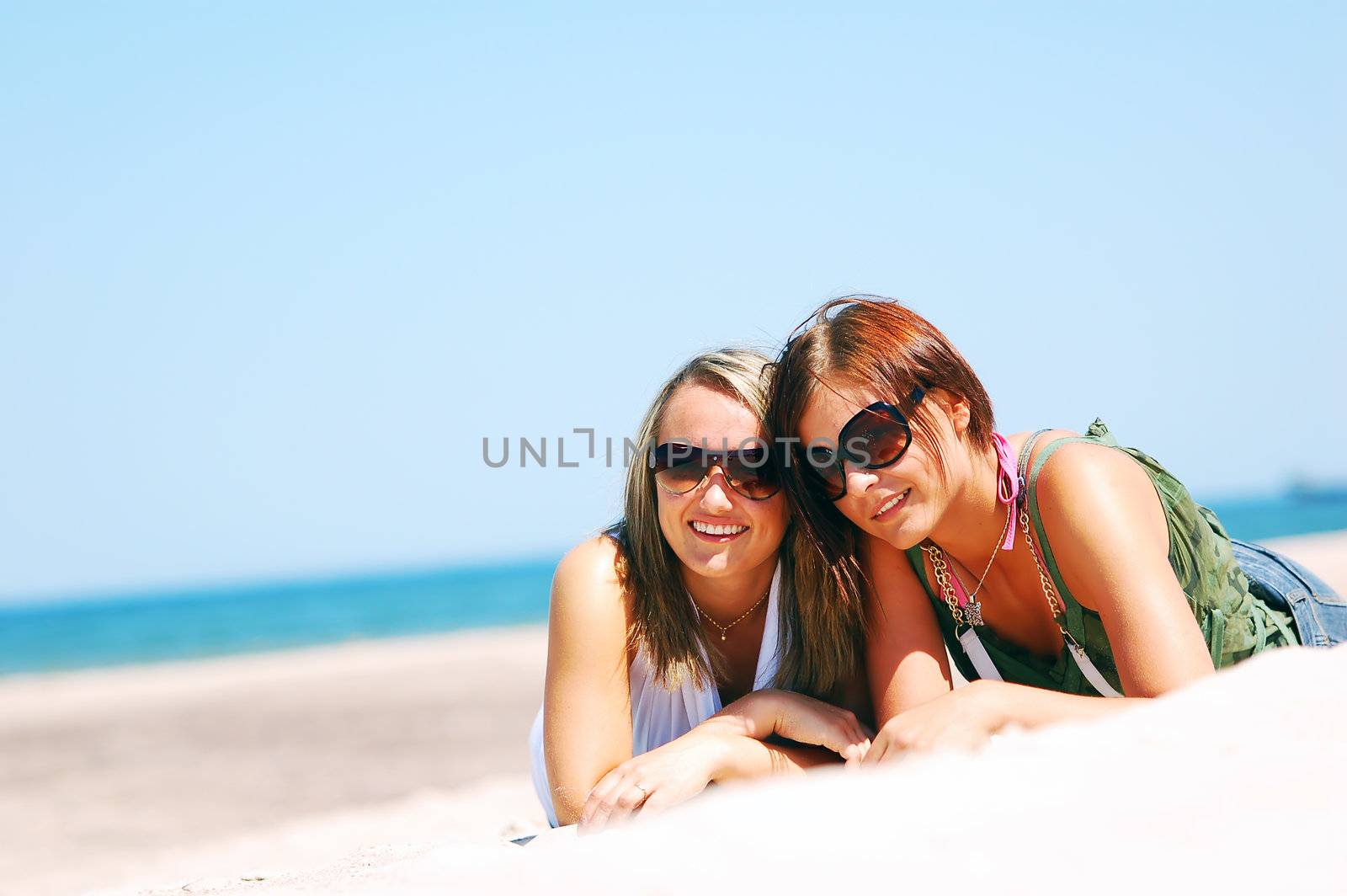 Young attractive girls enjoying together the summer beach