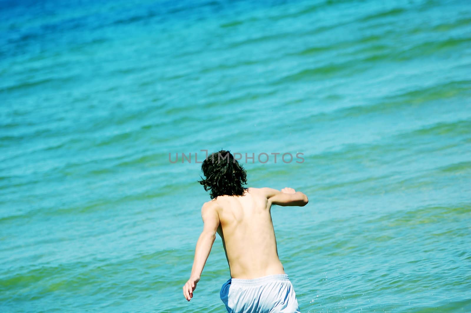 Boy running the the sea. Enjoying summertime