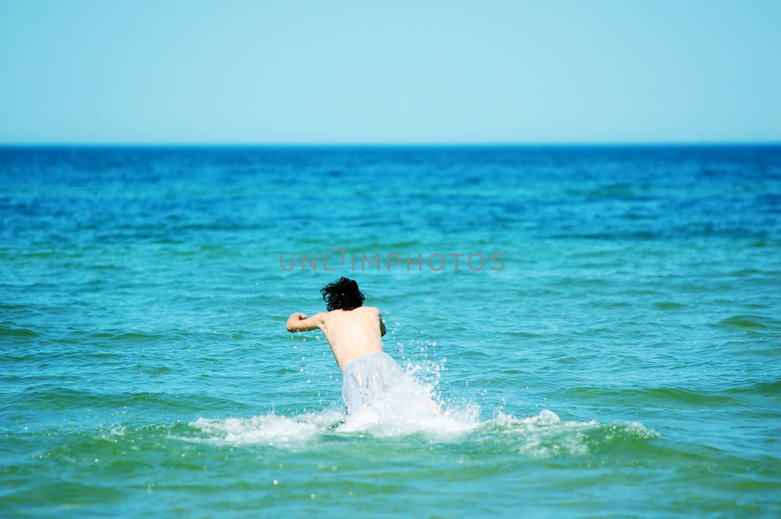 Boy running the the sea. Enjoying summertime