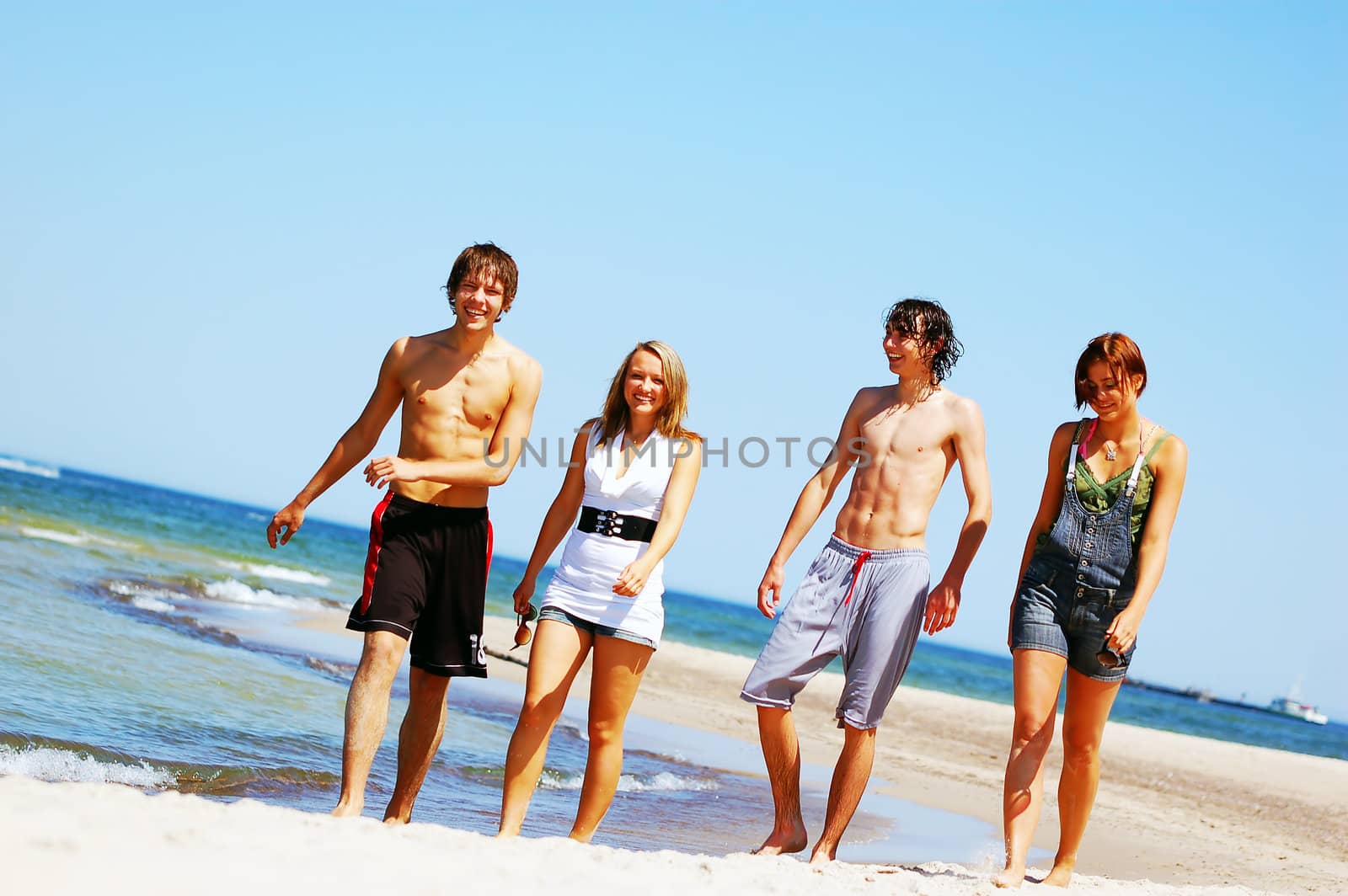 Young friends on the summer beach by photocreo