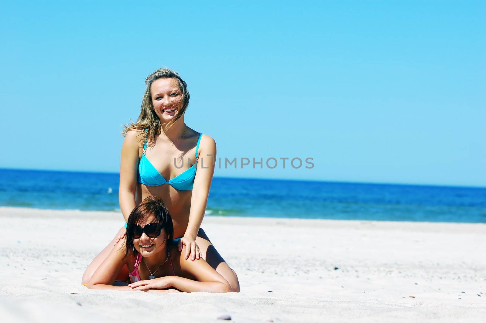 Young attractive girls enjoying together the summer beach