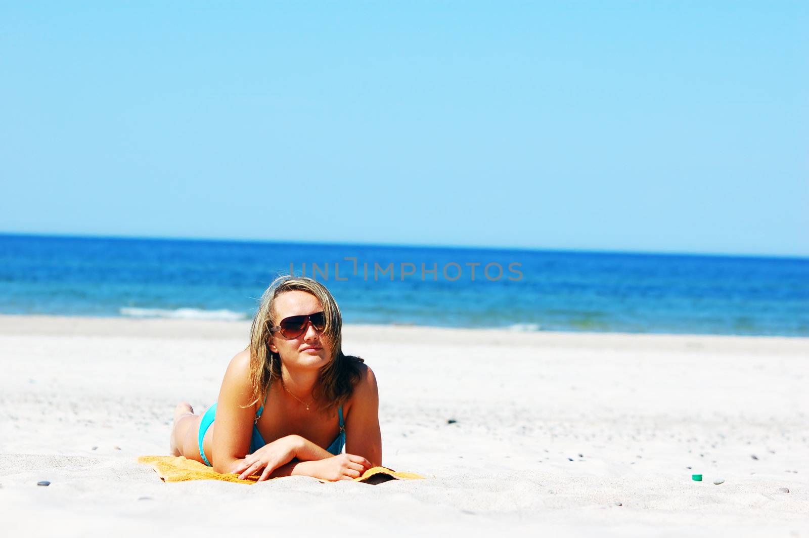 Beautiful woman relaxing on the beach. Lots of useful copyspace