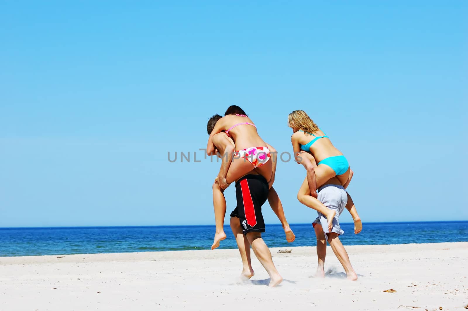 Young attractive friends having fun the summer beach