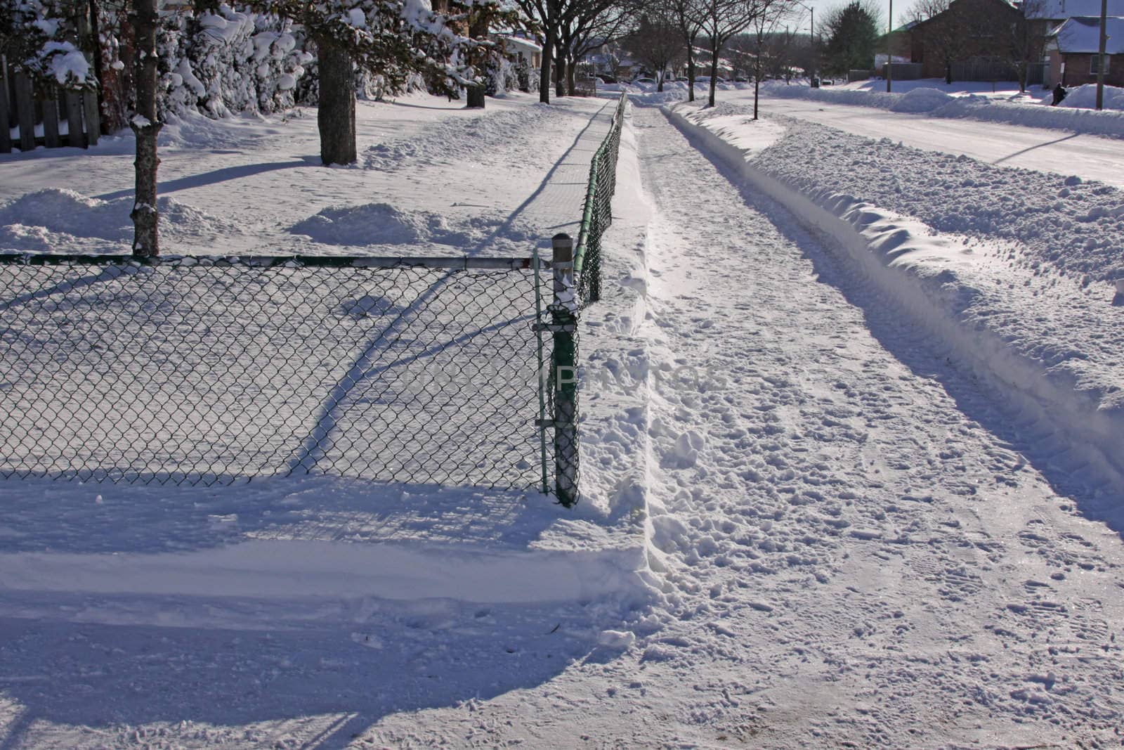 Snow fall in the suburbs, featuring a cleared side walk corner.