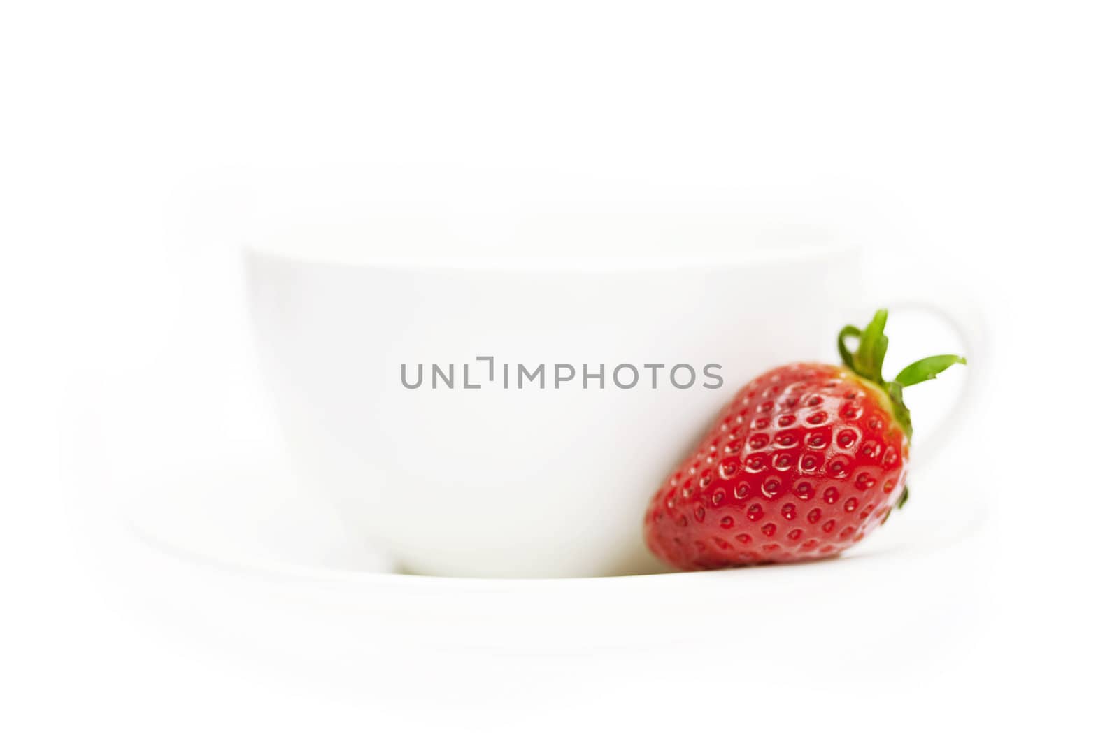 white cup and juicy strawberries isolated on white