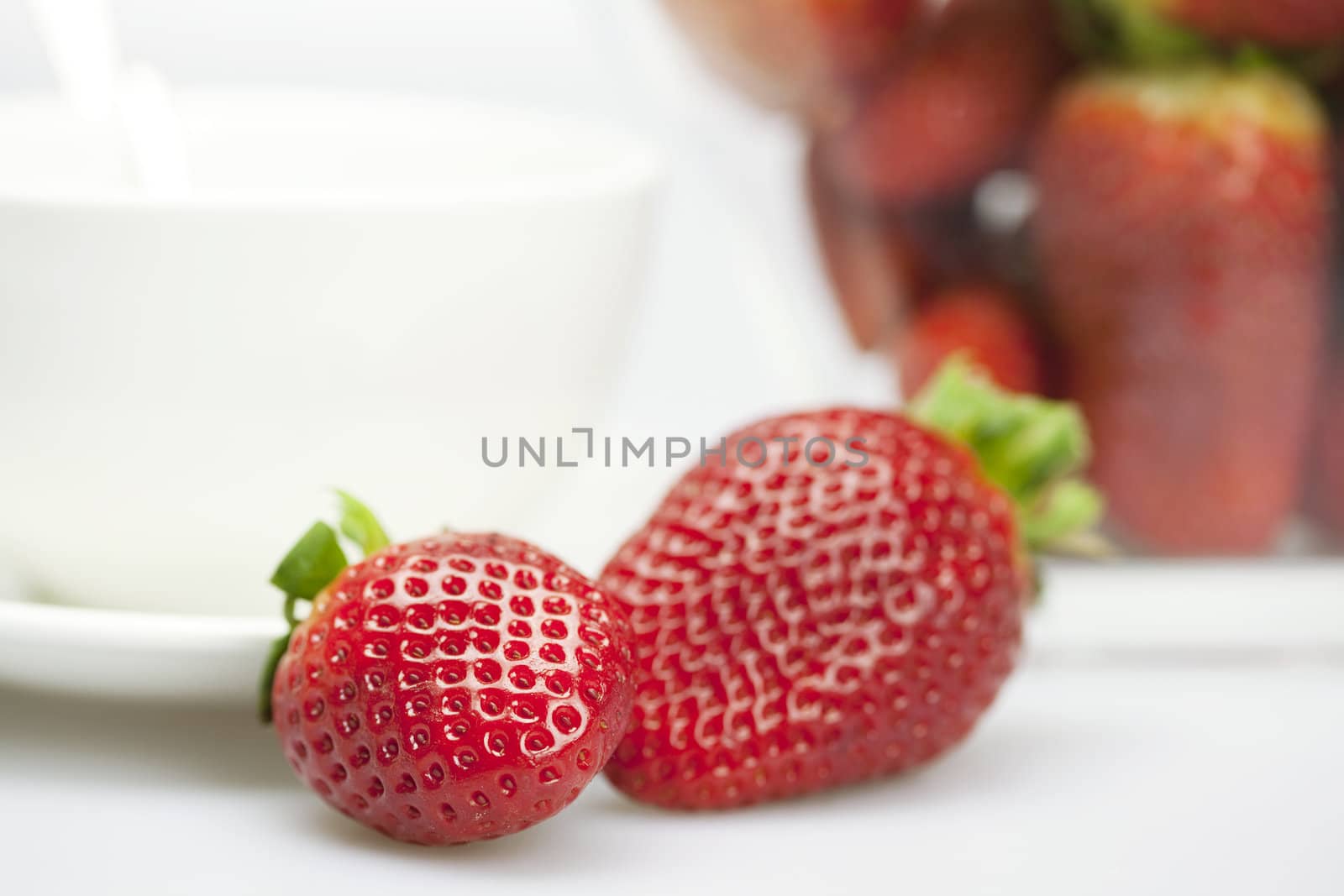 juicy strawberries and a cup isolated on white