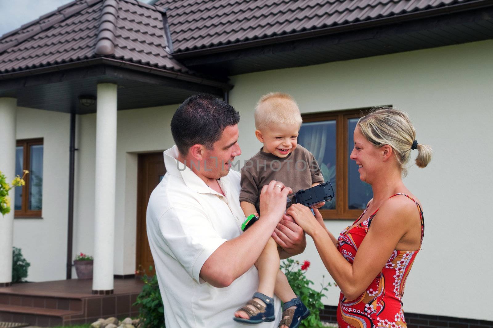 Happy family in front of their house