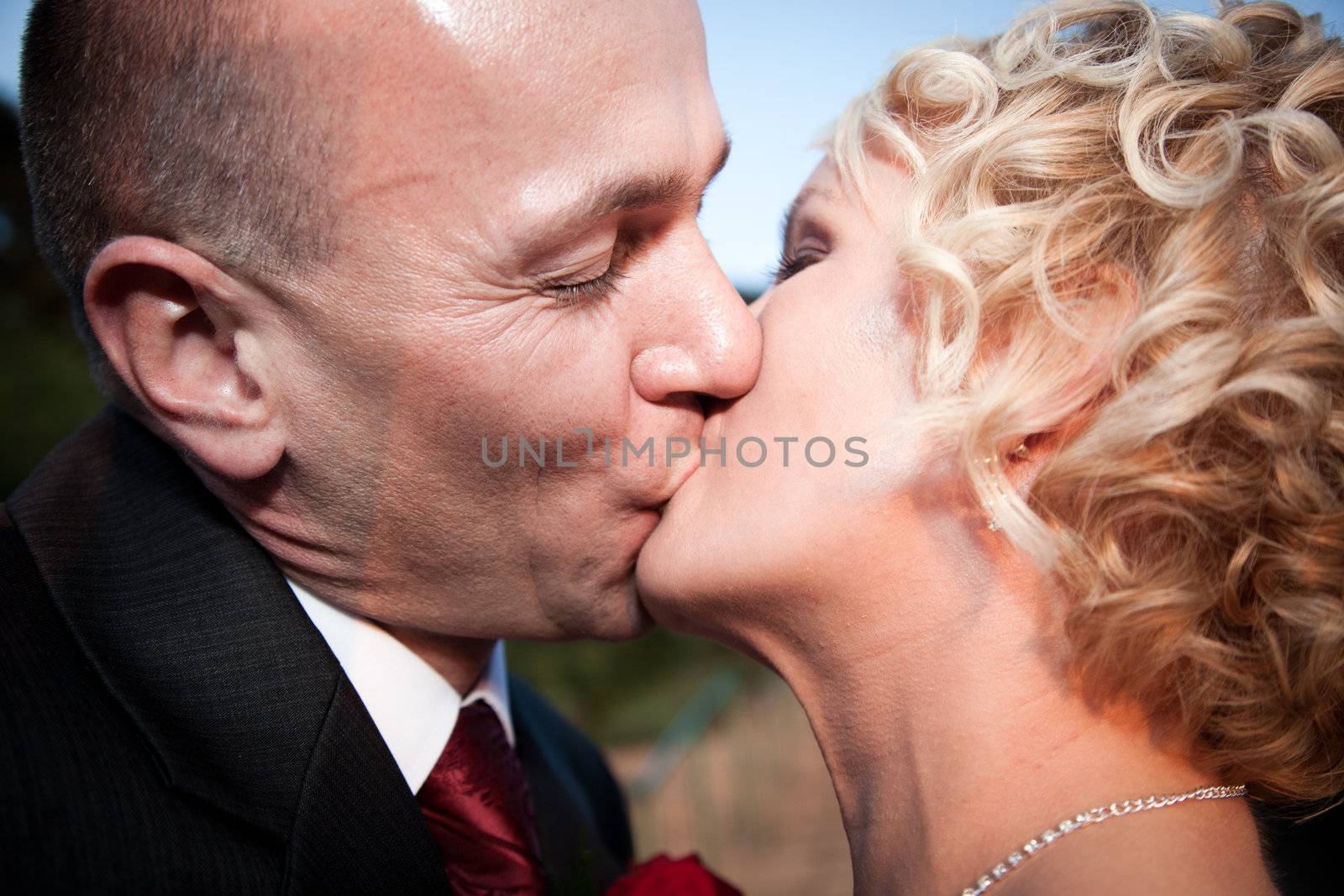 Happy bride and groom kissing by photocreo