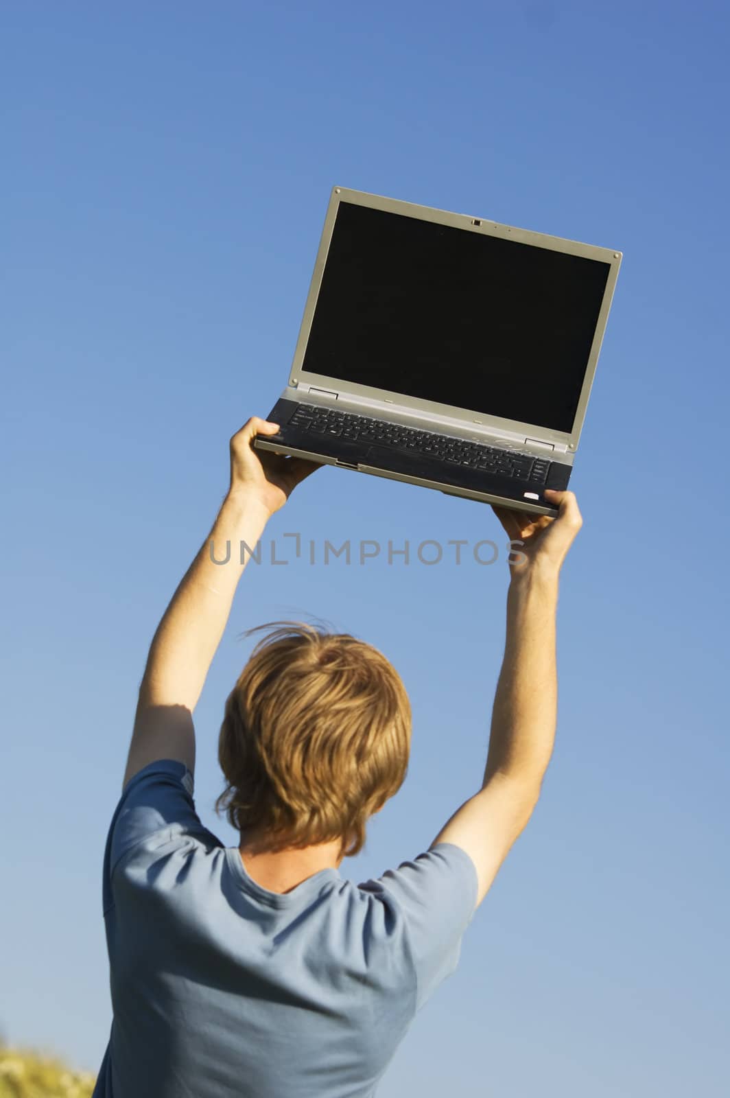 Boy and laptop on sky background