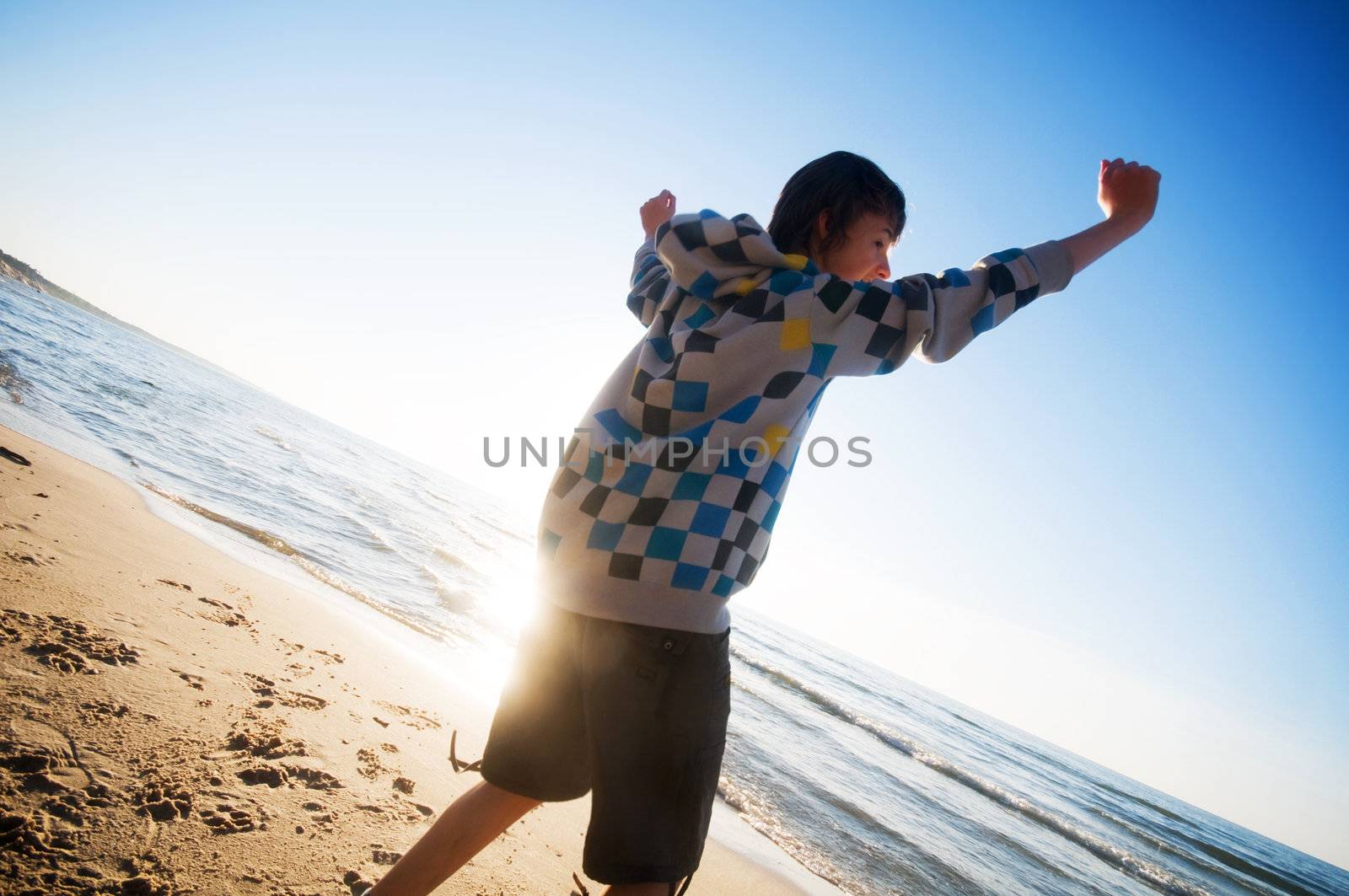 Happy boy jumping for joy at the beach