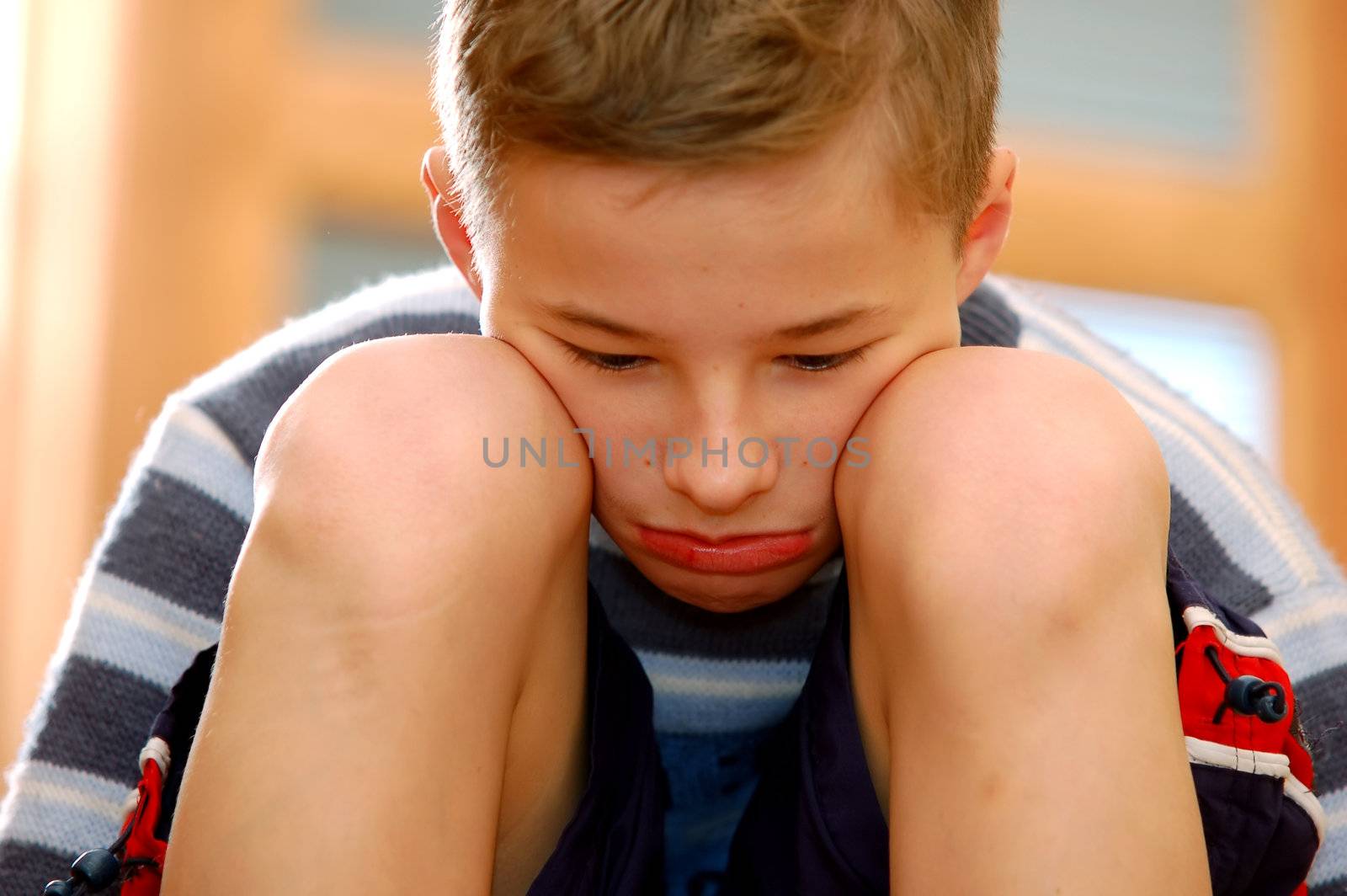 Portrait of young boy sitting sadly