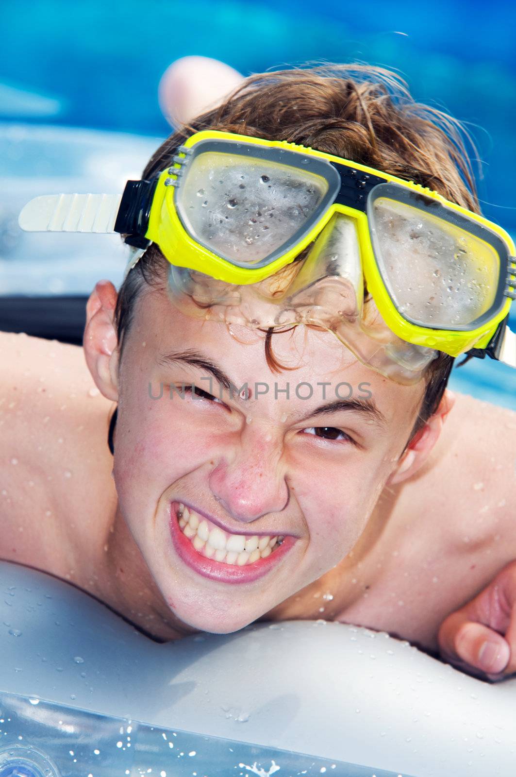 Happy playful boy swimming in a pool