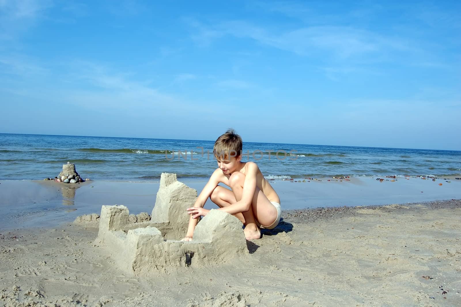 Boy playing on the beach in summertime