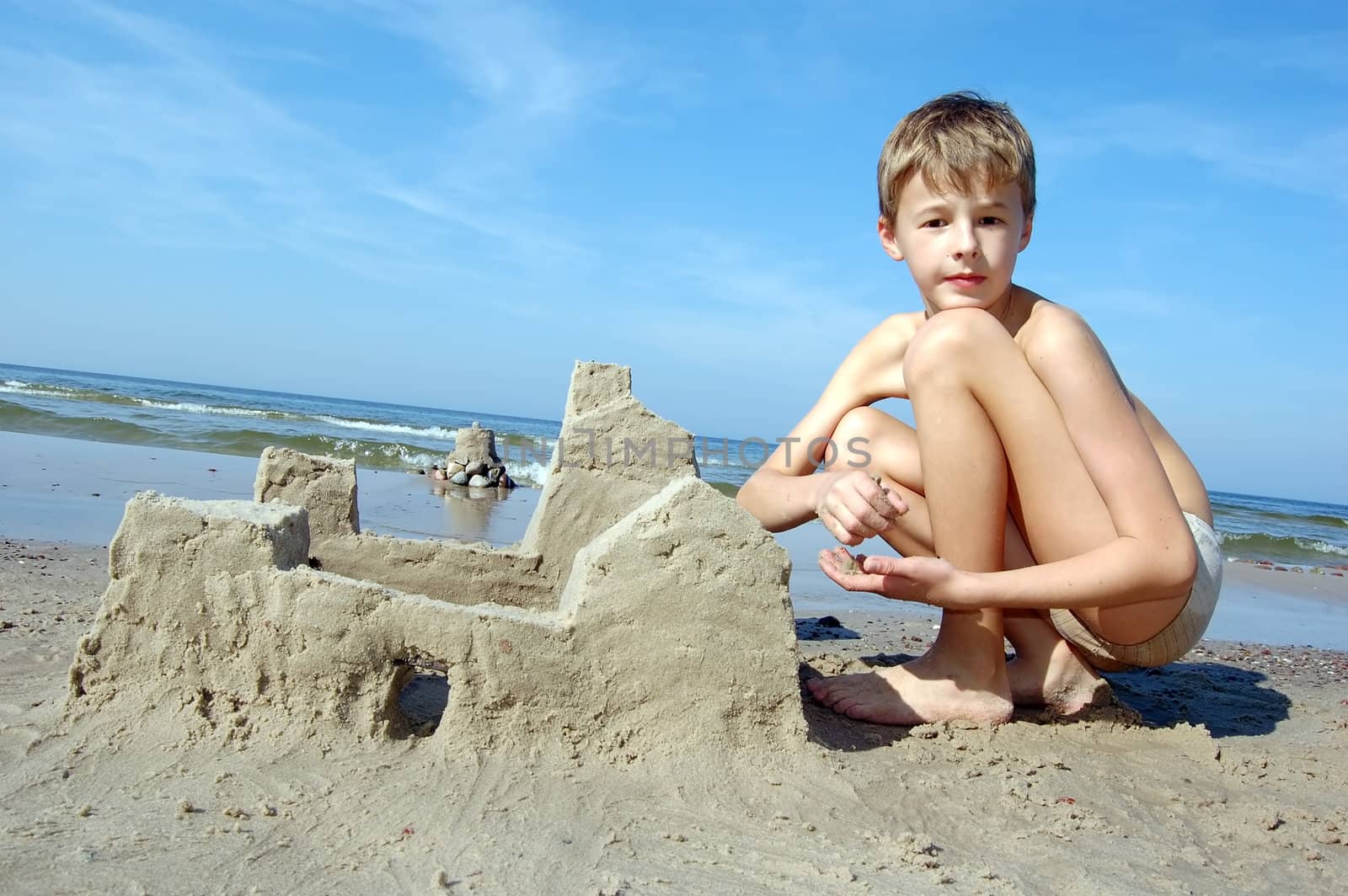 Boy playing on the beach in summertime