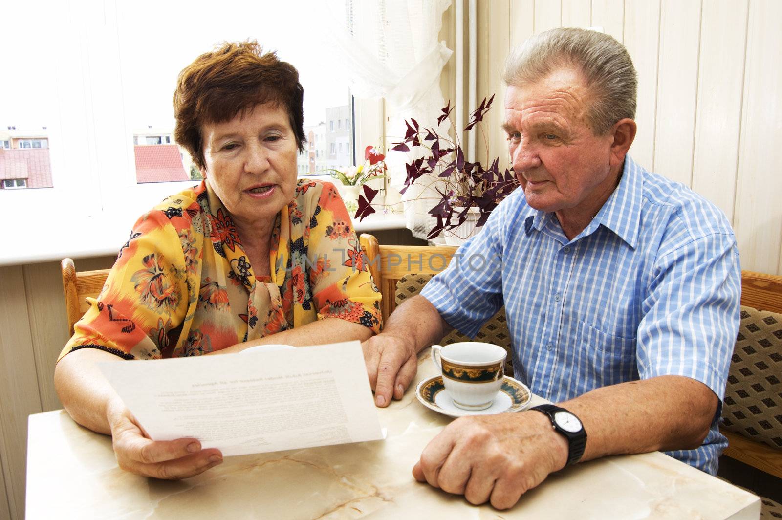 Senior couple studying document together in home