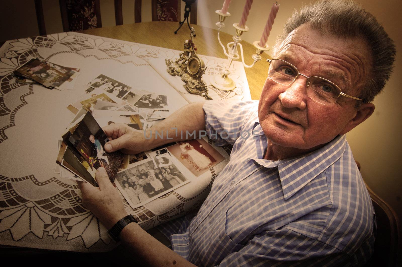Senior man looking at old photographs. Reminisce about the past