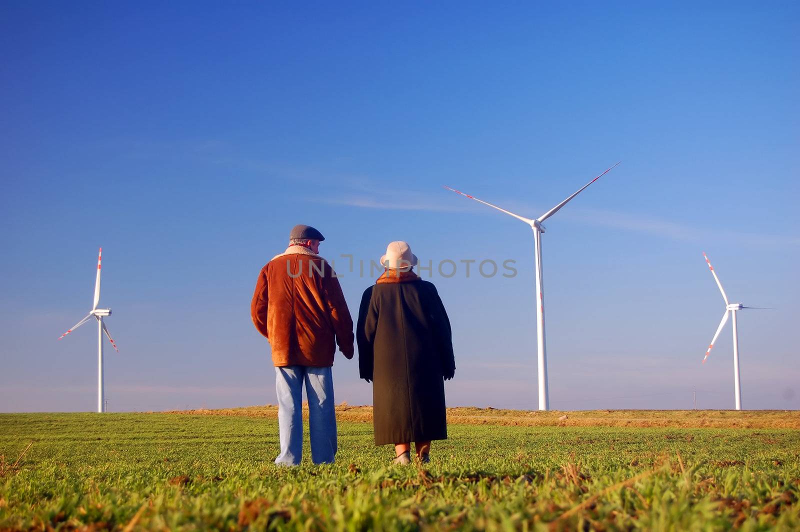 Seniors' couple looking on wind turbines