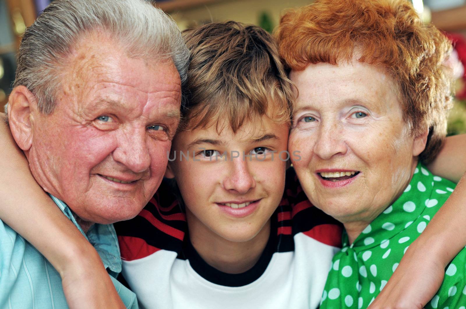 Grandparents with grandson embracing together portrait