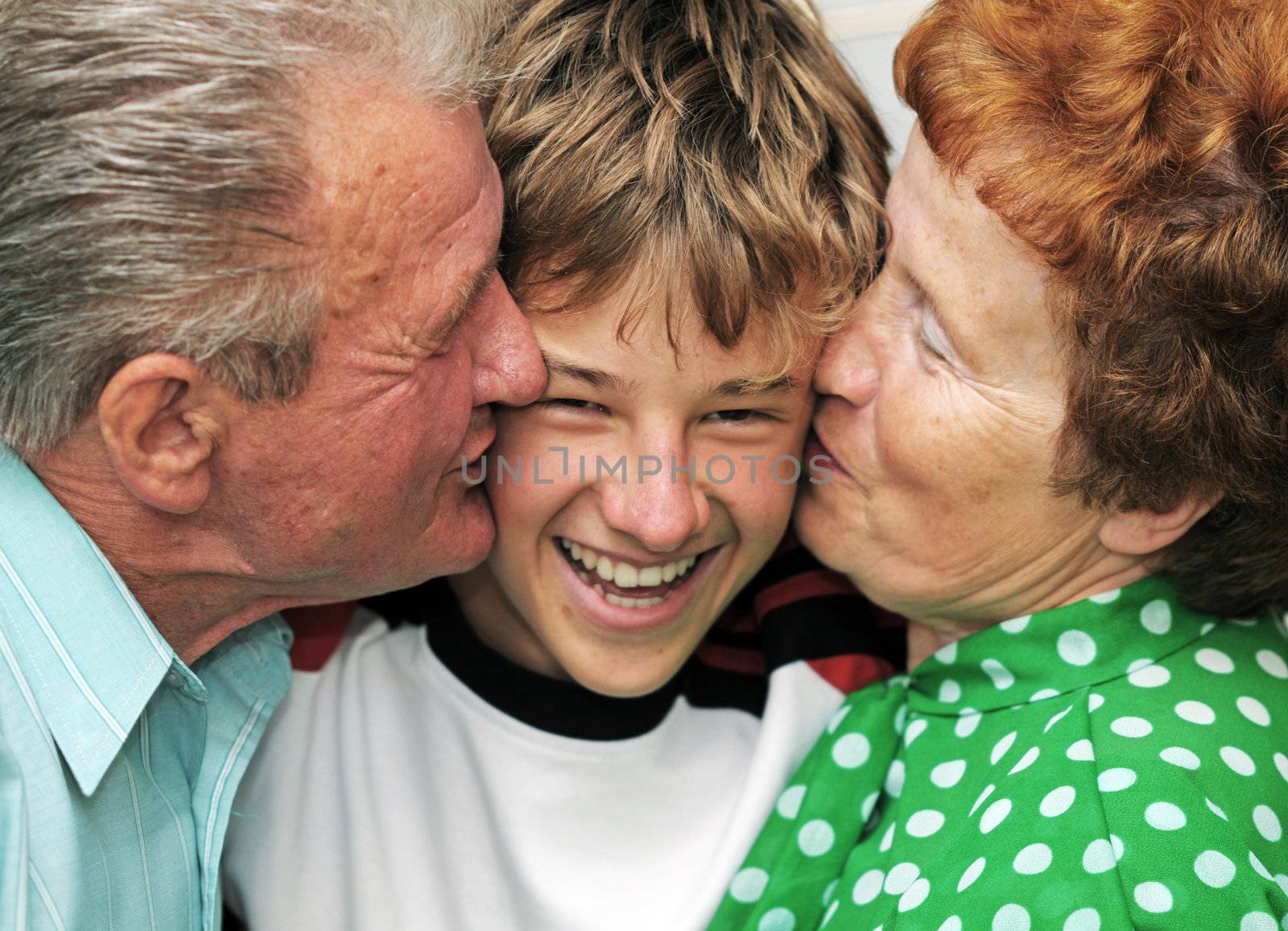 Grandparents kissing their grandson. Potrait