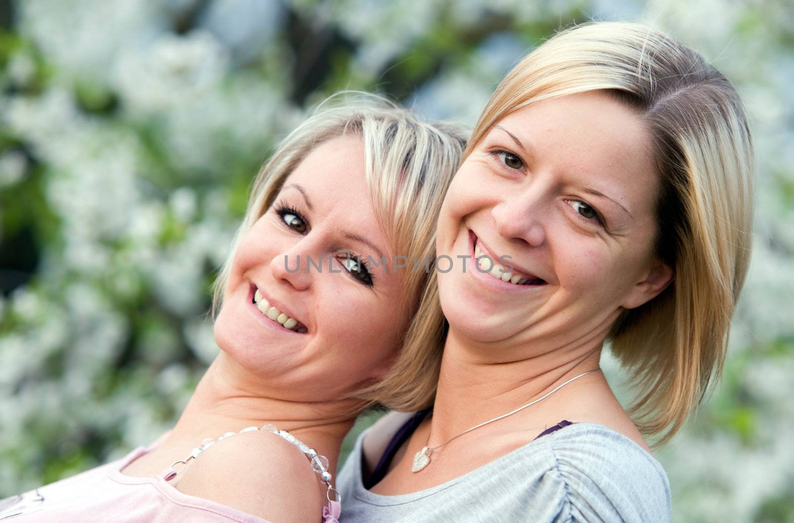 Happy sisters smiling. Nature background