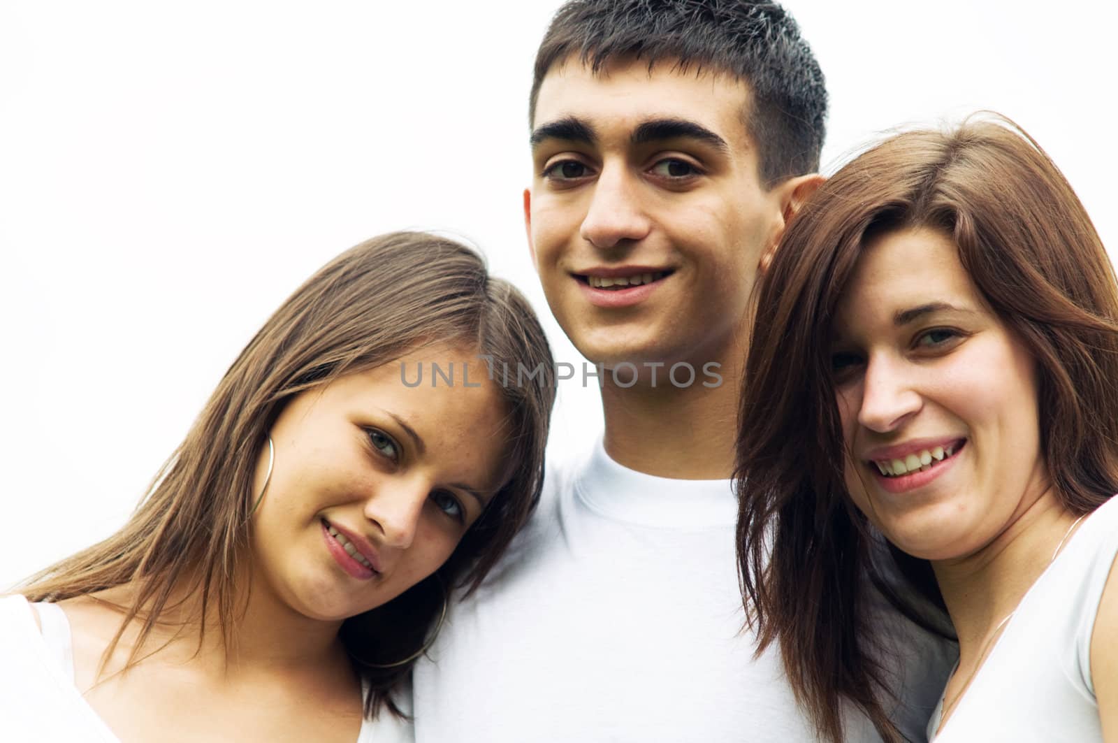 Three young happy friends standing together and smiling