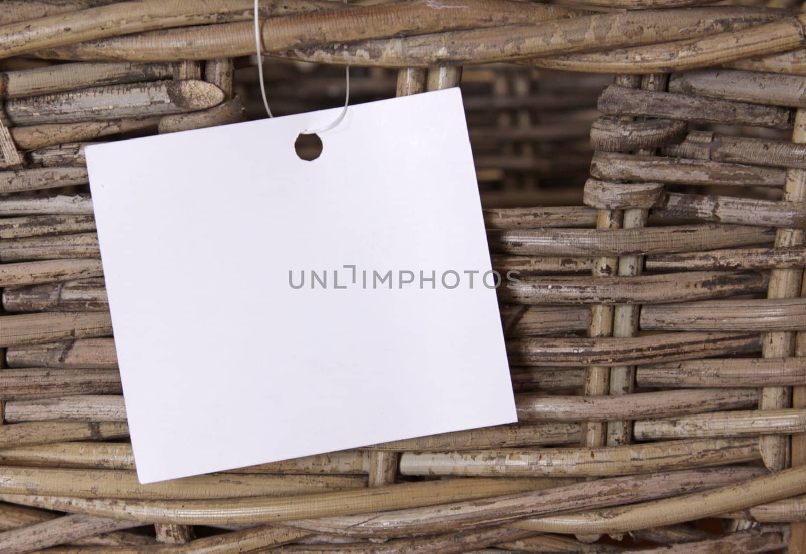A wicker basket with a white label attached to it.