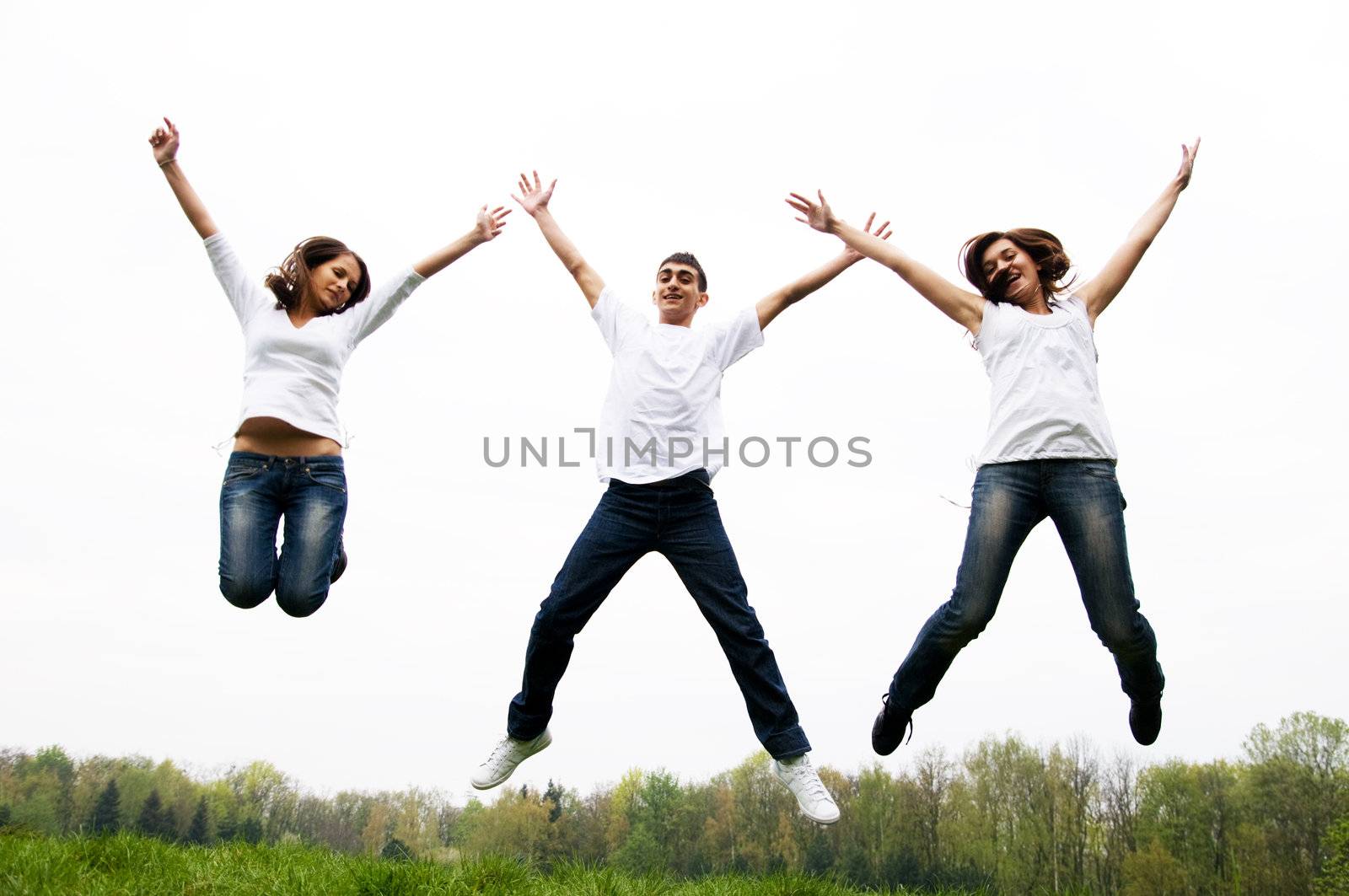 Happy friends jumping by photocreo