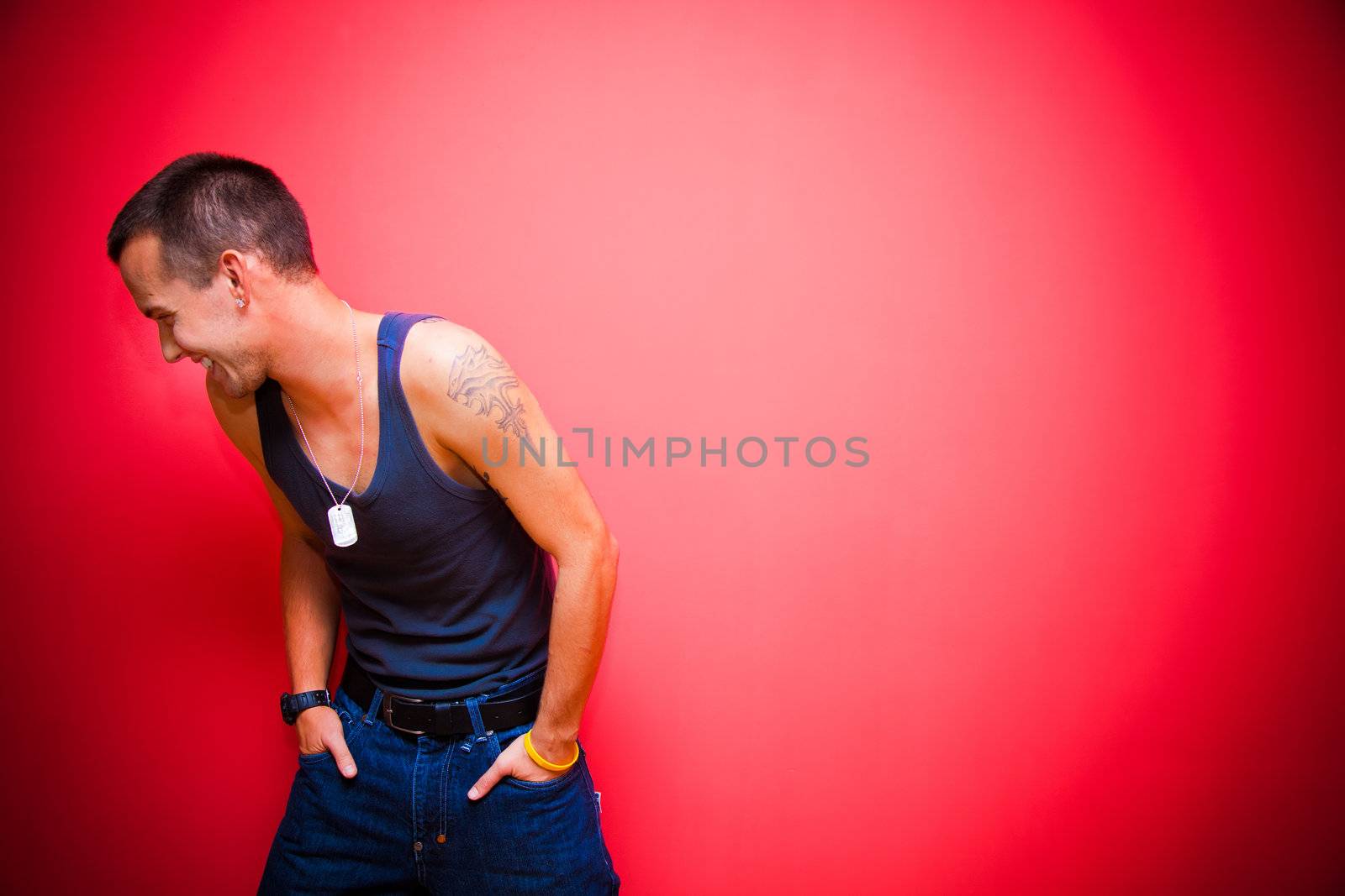 Young handsome man on red wall by photocreo