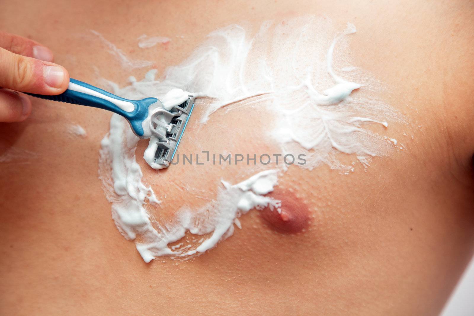 Young man shaving his chest, torso by photocreo
