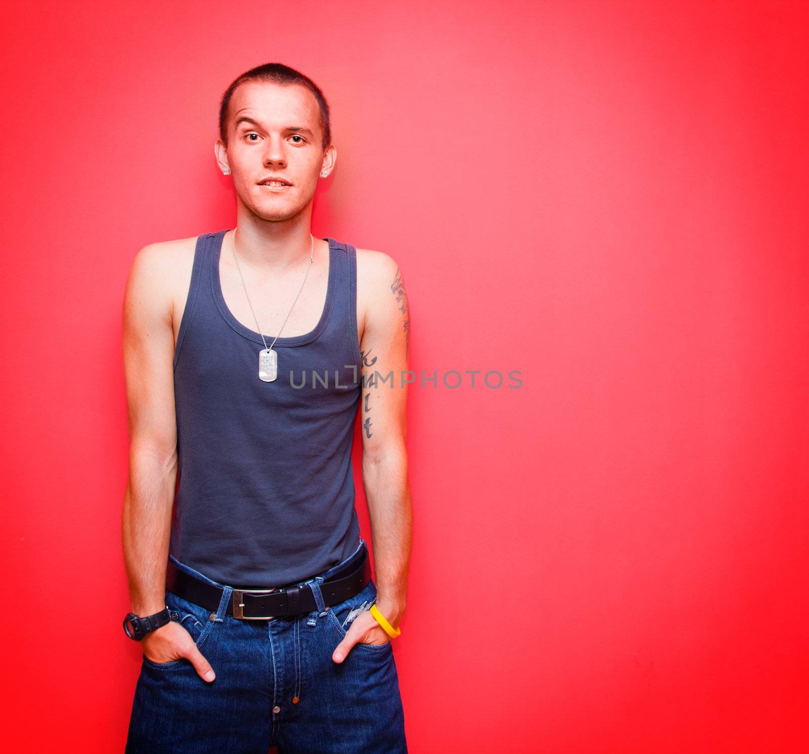 Young handsome man on red wall by photocreo