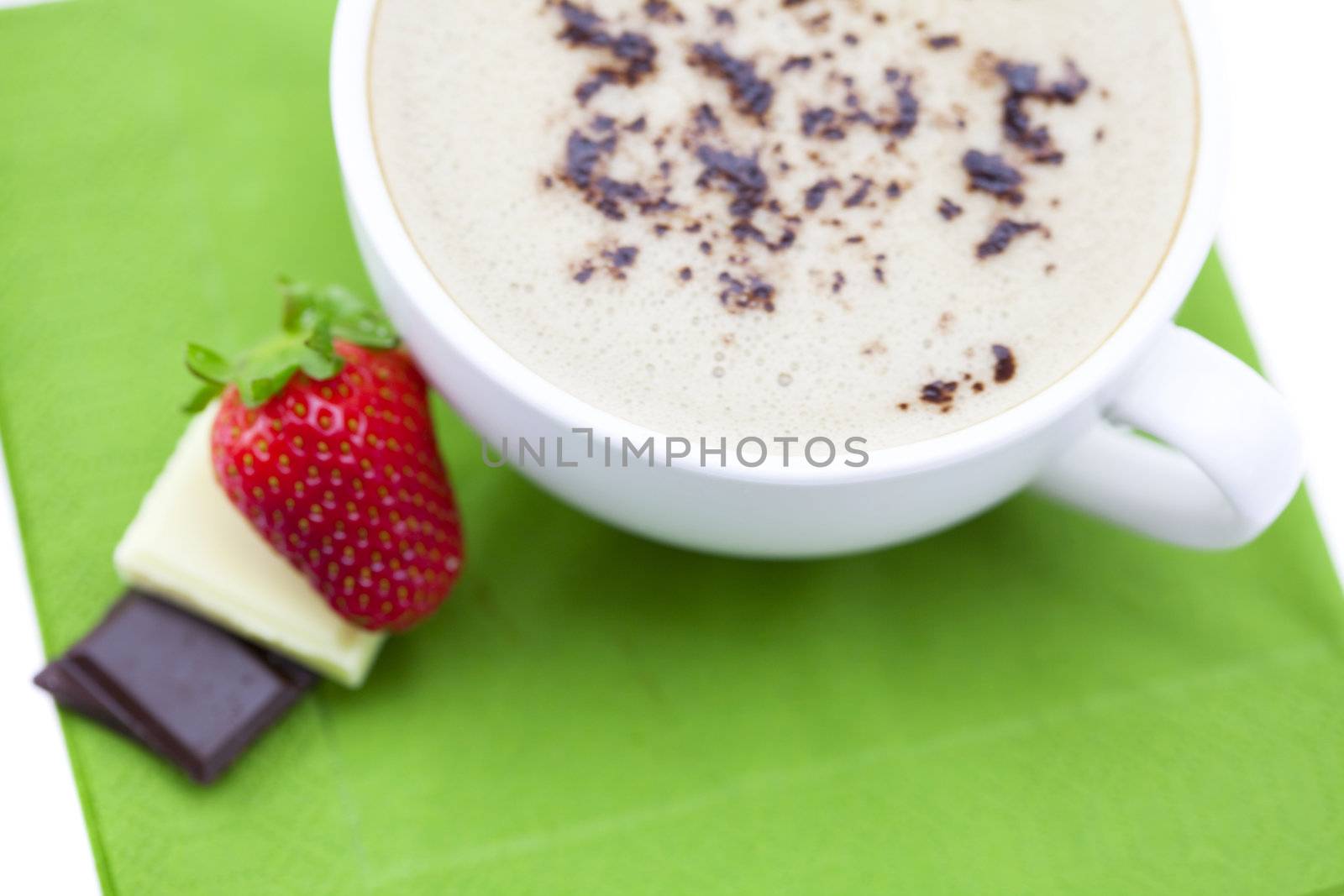 cup of cappuccino with chocolate and strawberry on a napkin