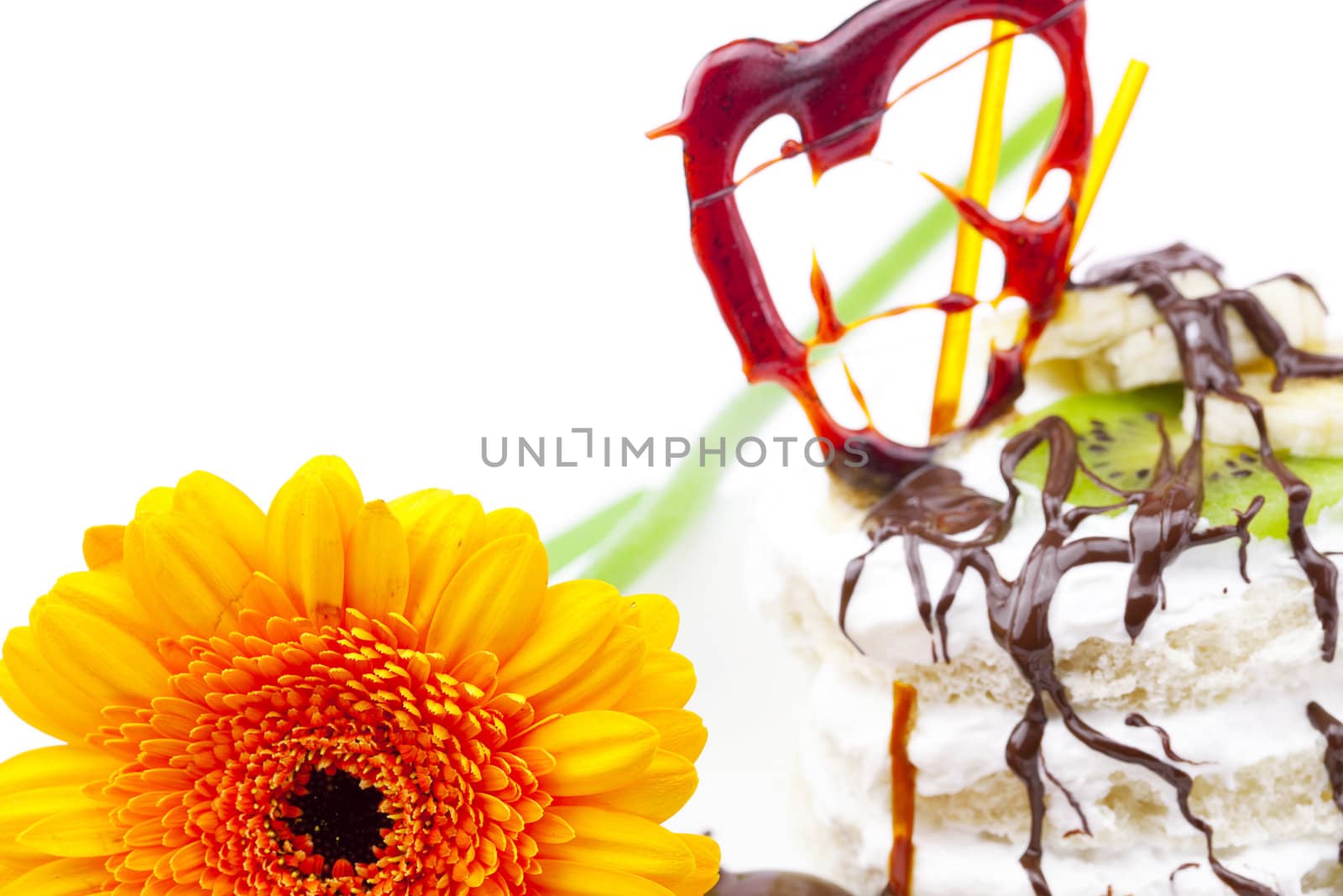 cake with caramel, chocolate, kiwi fruit and flower isolated on white