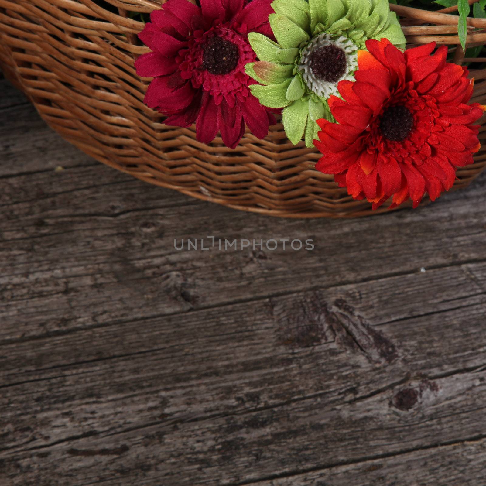 A basket of colorful flowers lying on a wooden table