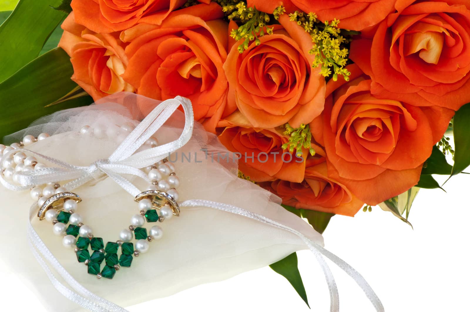 necklace and orange roses on a white background