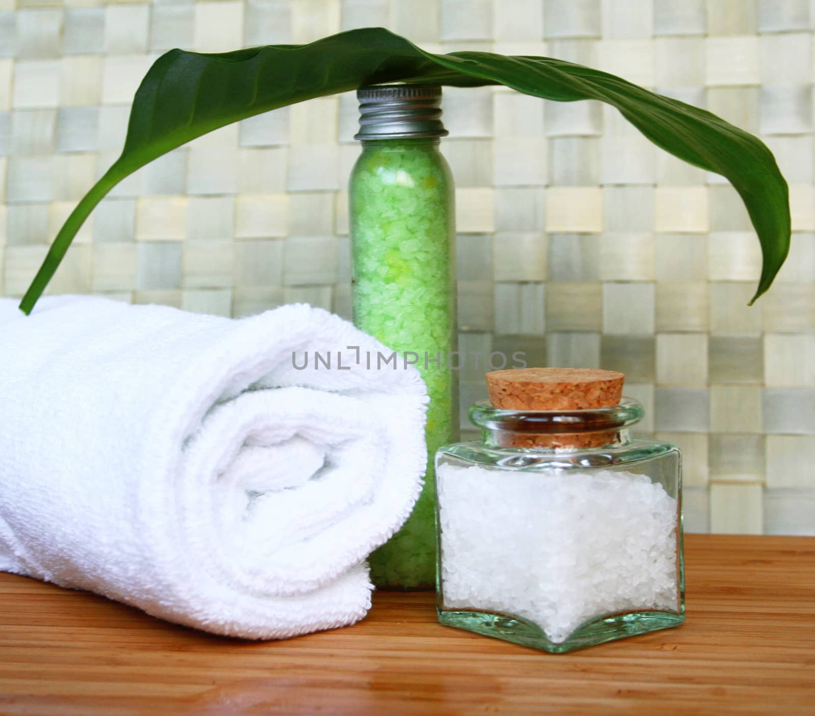White bath towel, bottles of sea salt in spa composition


