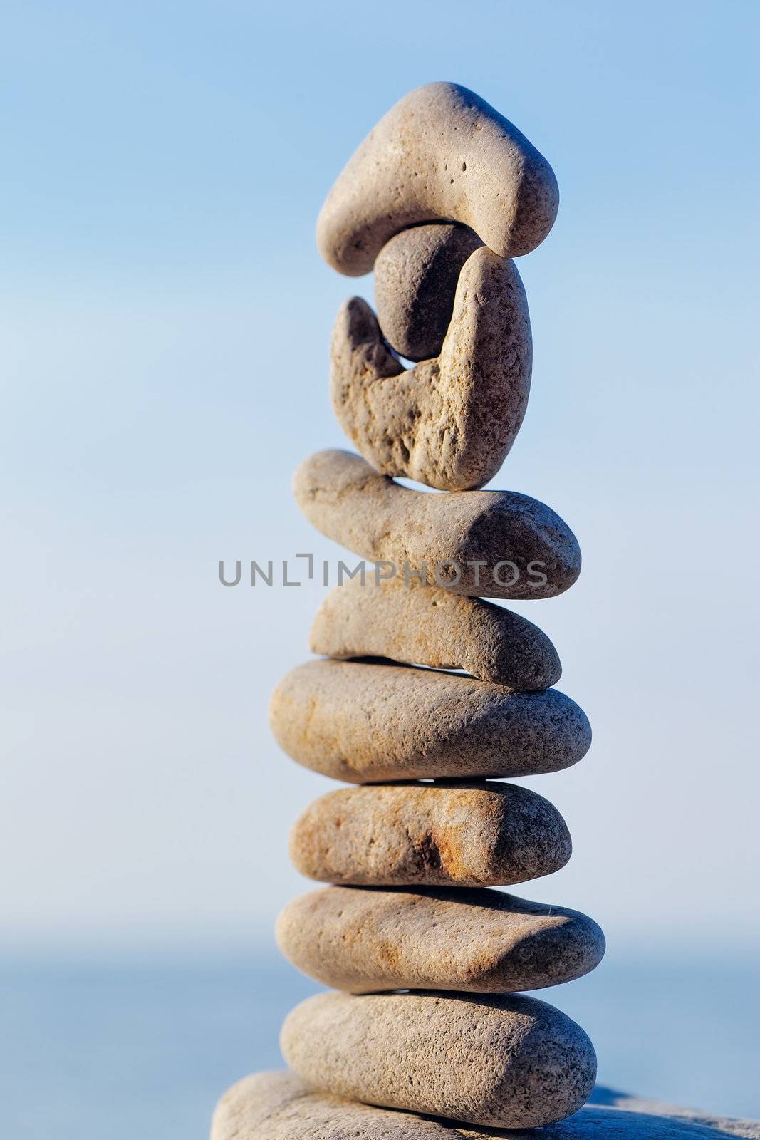 Balancing of pebbles each other on a sky background