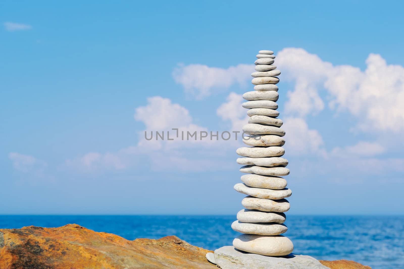 Stack of pebbles in the balance on the sea boulder