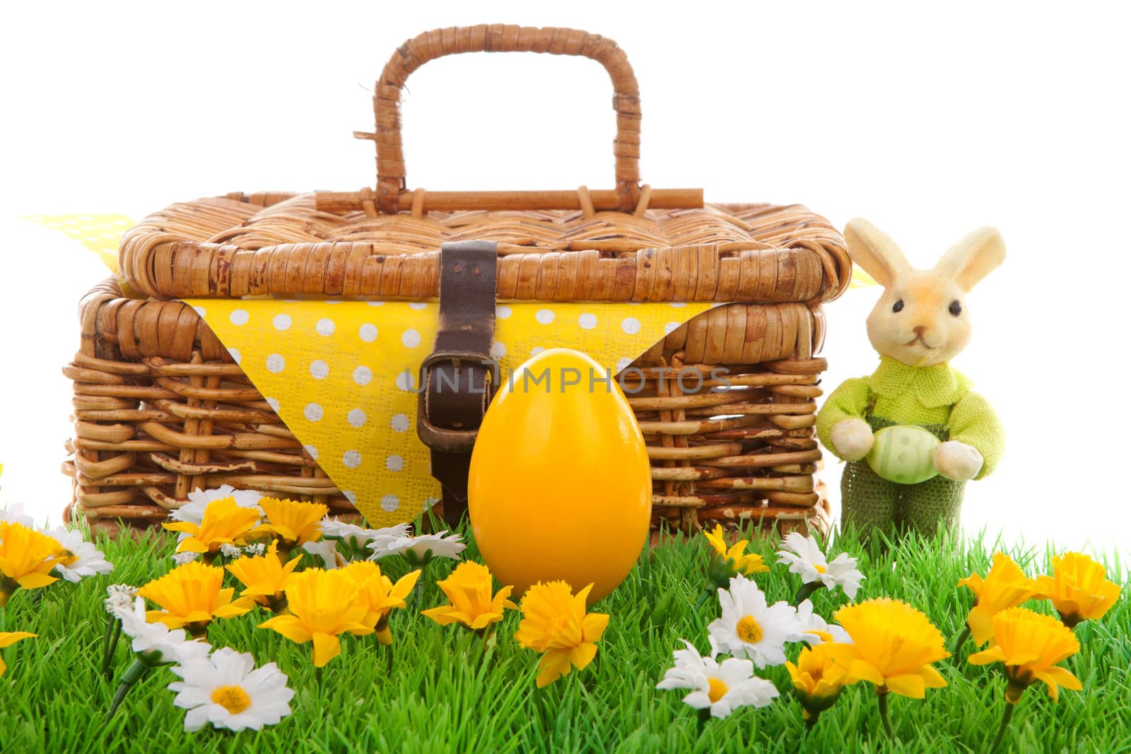 Yellow easter egg, bunny and basket on green grass with flowers