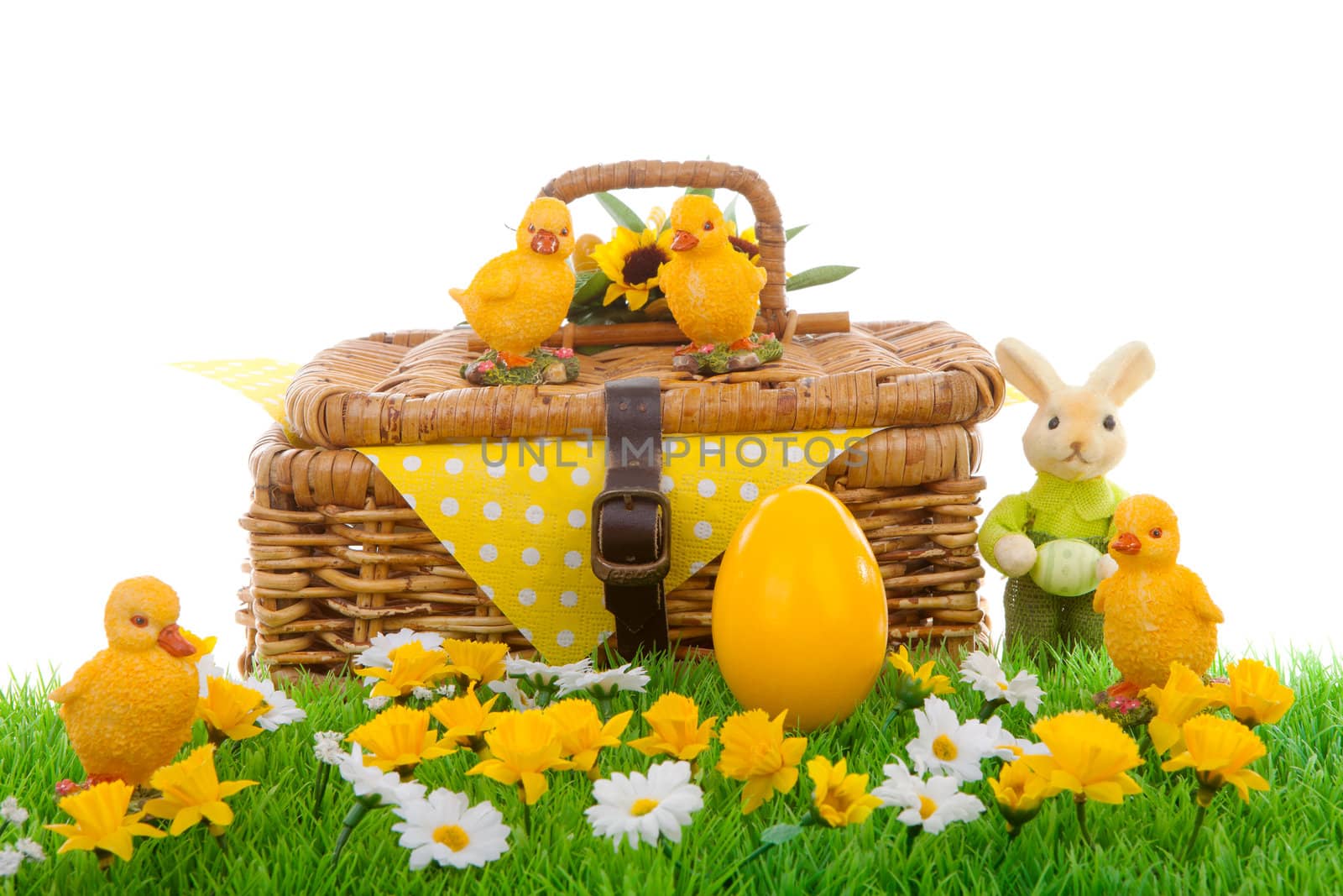 Yellow easter egg, bunny, chickens and basket on green grass with flowers