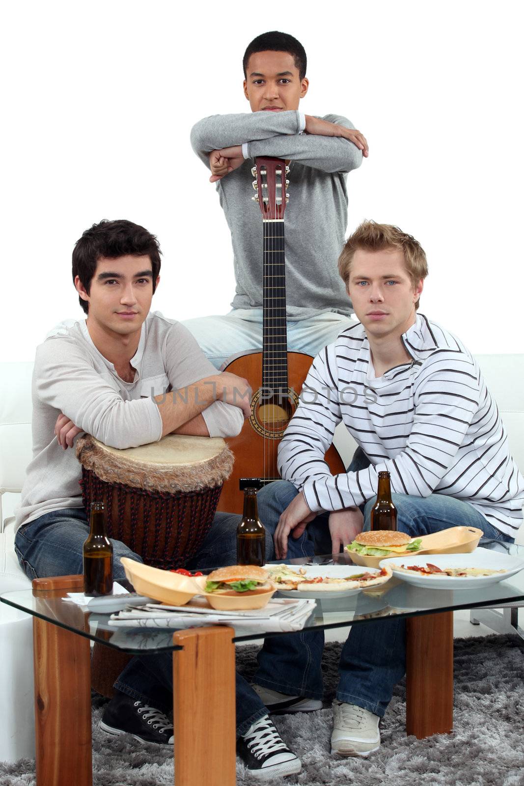 Young men at home with musical instruments by phovoir