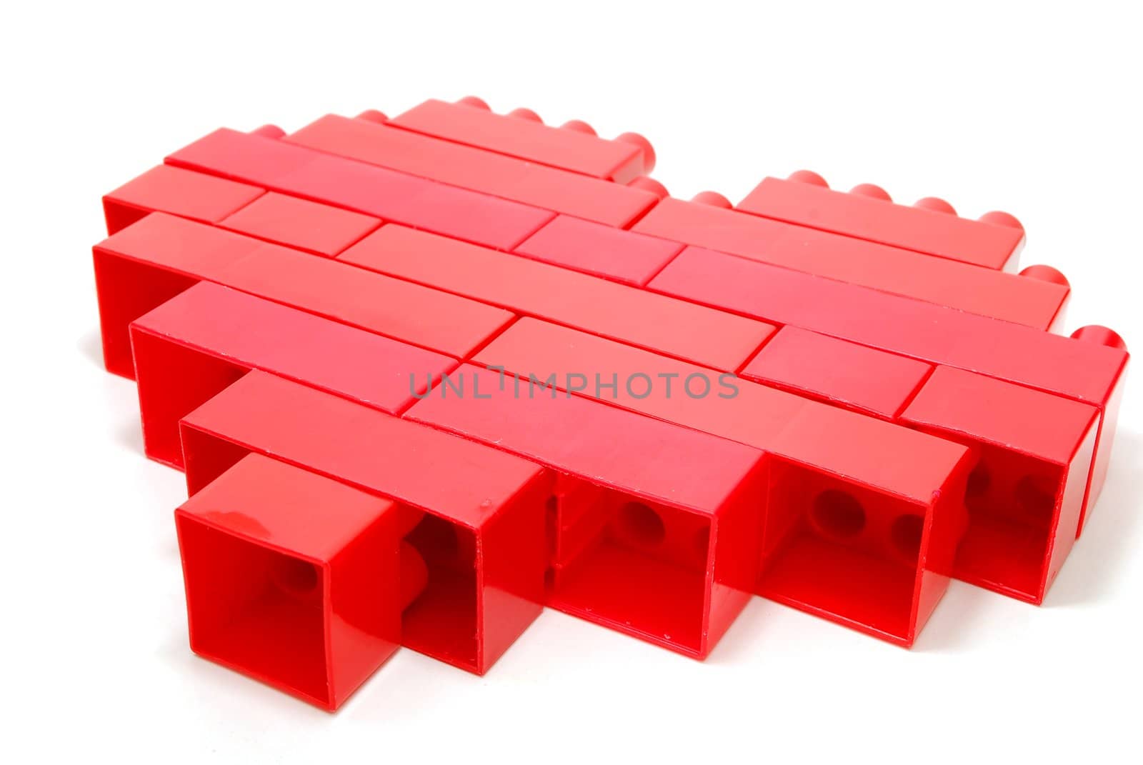 Single Red Heart made of Lego Blocks Laying Isolated on White