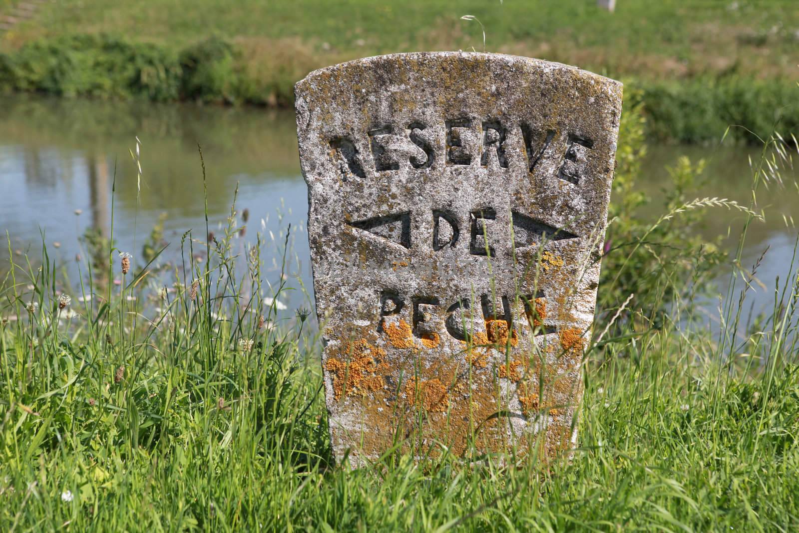 Stone sign post by a river by phovoir