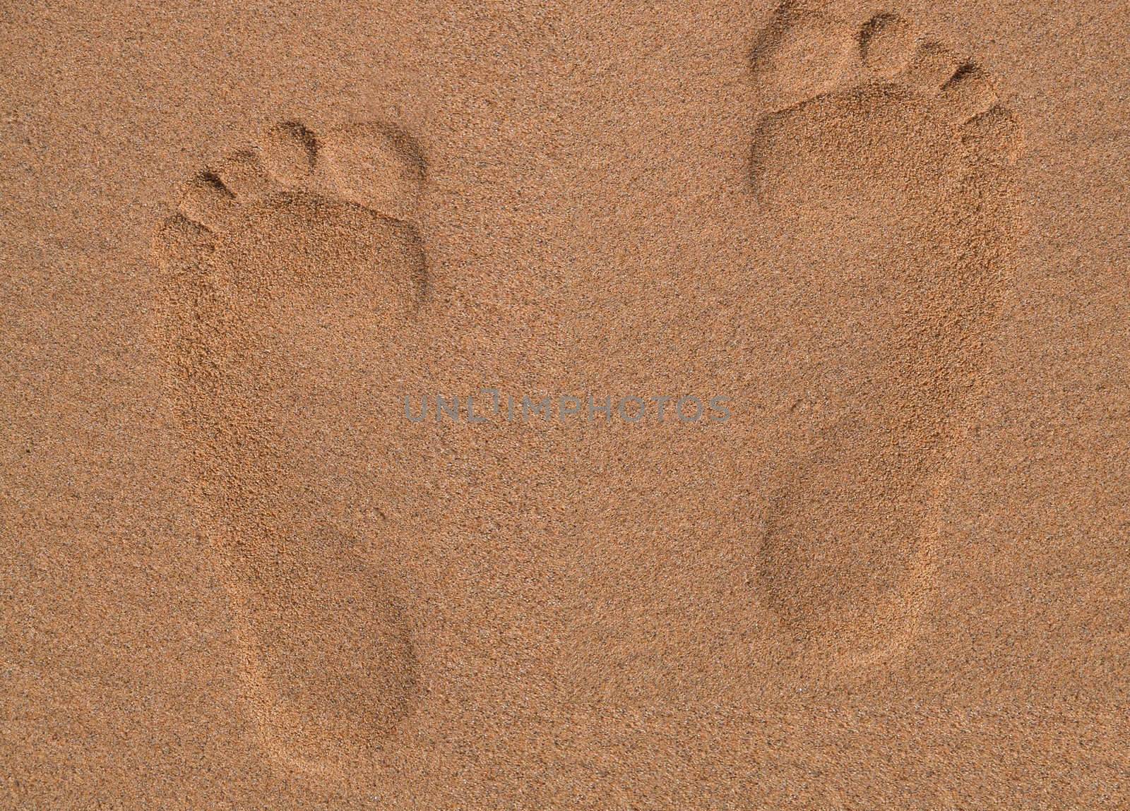 Two Footprints in sand at the Beach