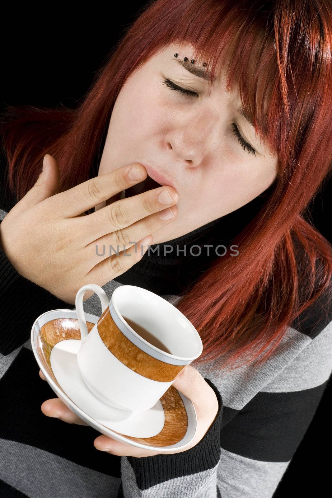 Girl preparing to drink her cup of coffee. Tired.

Studio shot.