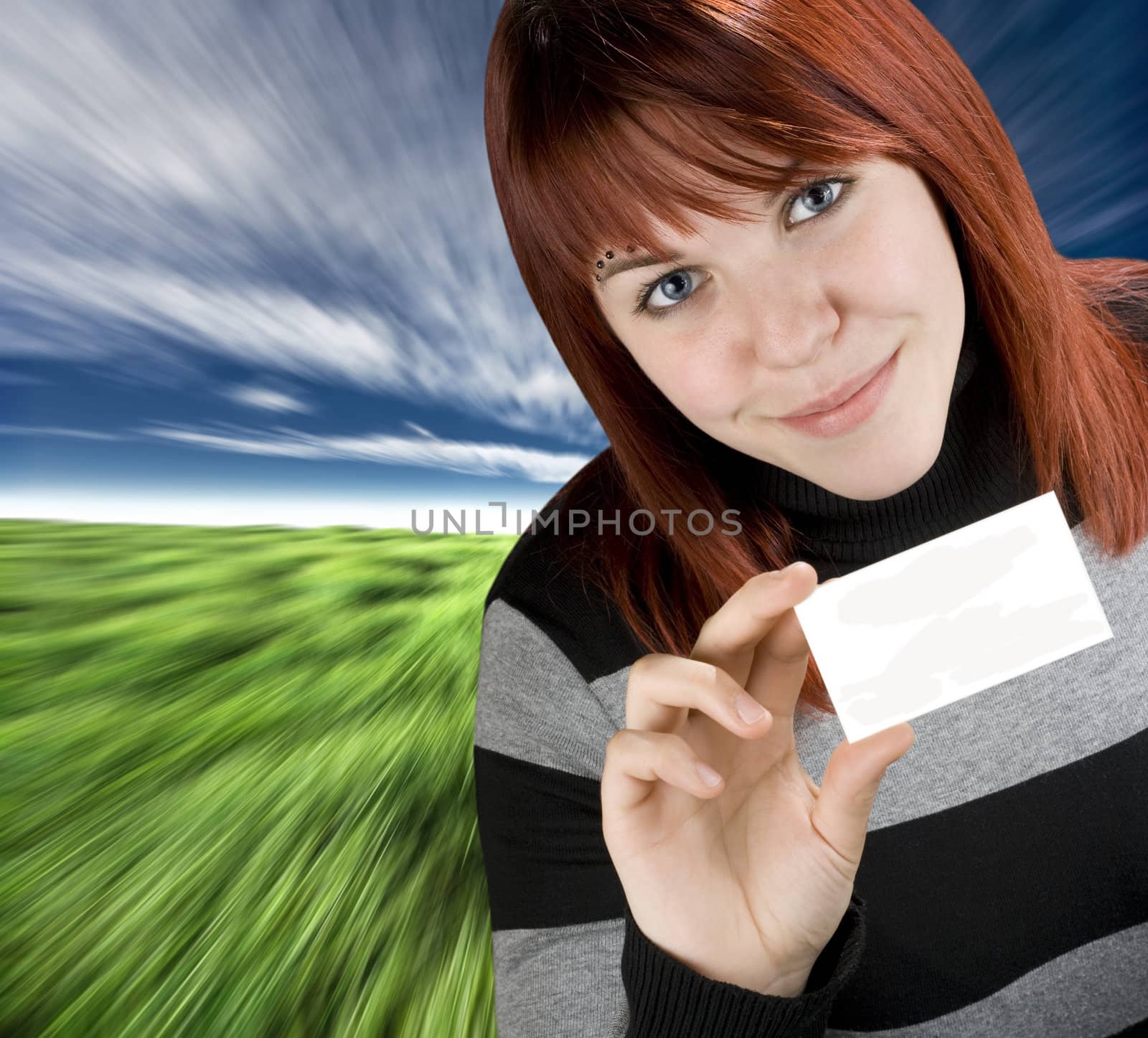 Smiling successful girl with red hair holding a blank empty business or greeting card.

Studio shot.