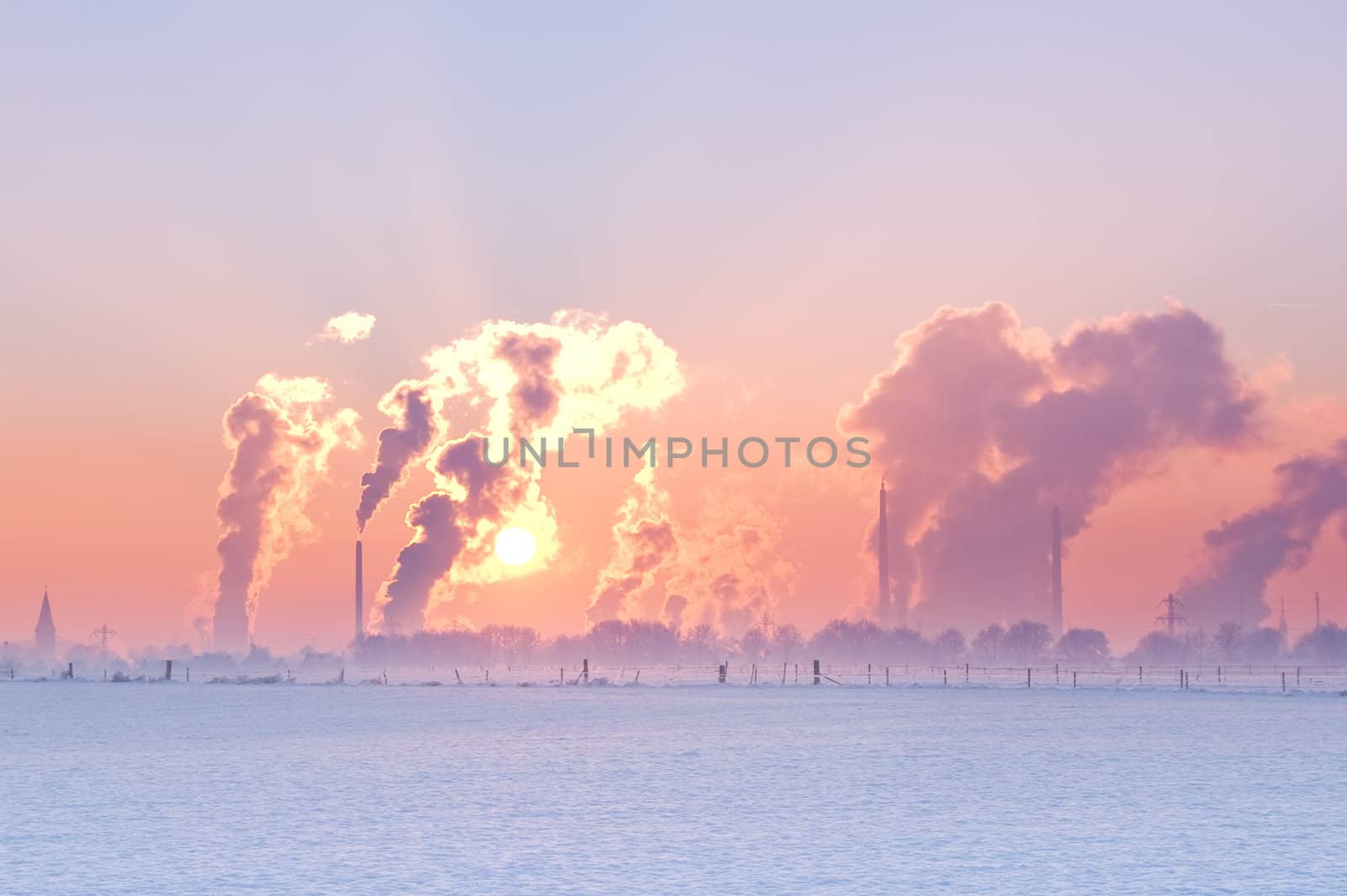 nice winter landscape with industrial smokers with pale sunset